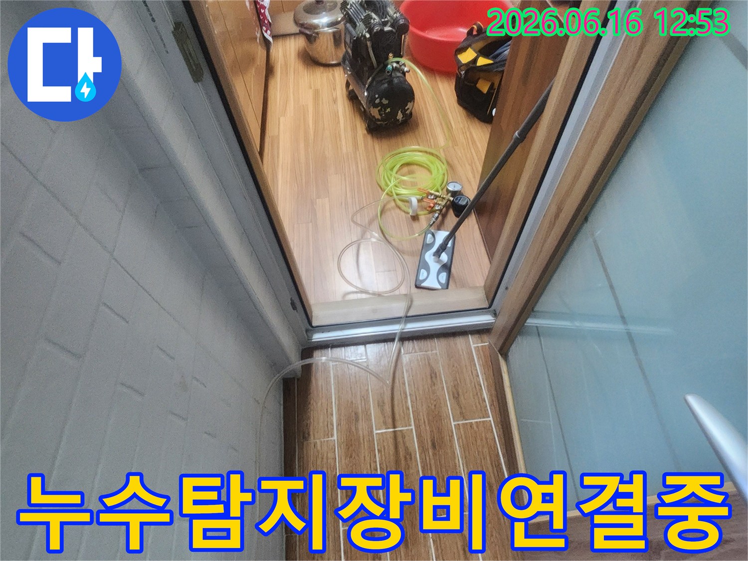 누수 엔지니어가 아파트 내부에서 누수-탐지 장비를 연결하며 작업을 준비하고 있습니다.
