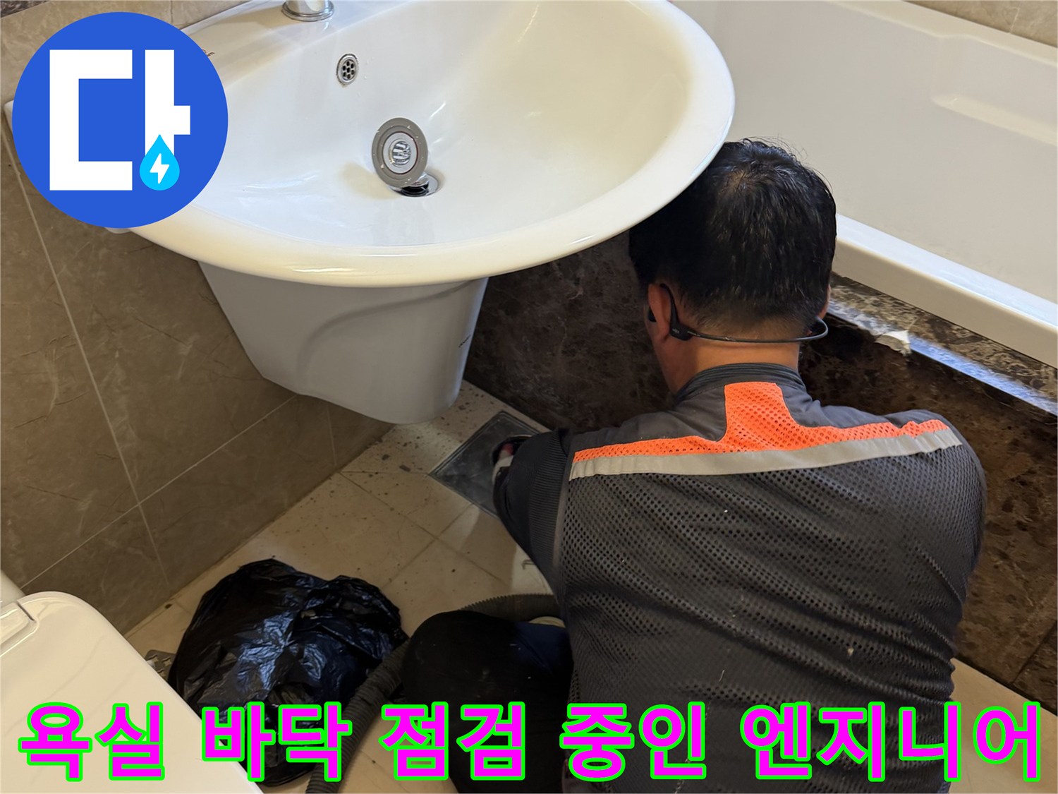 화성 향남 현장에서-엔지니어가 욕실 배수구 주변 누수 부위를 정밀하게 확인하고 있습니다.