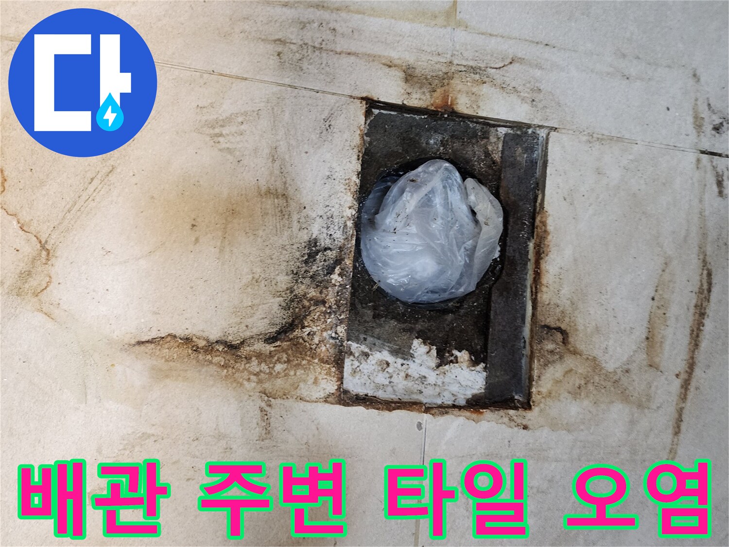 변기 하단 배관 주변의 젖고 변색된 타일 부위