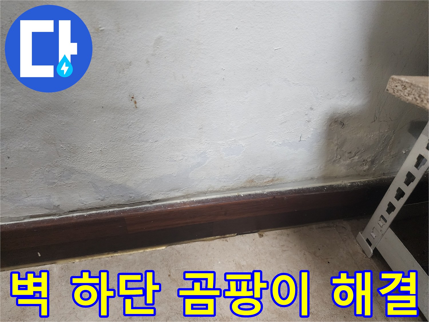 벽 하단부에 물이 스며들어 벽지가 젖고 곰팡이가 피어있는 누수 피해 현장 사진입니다.