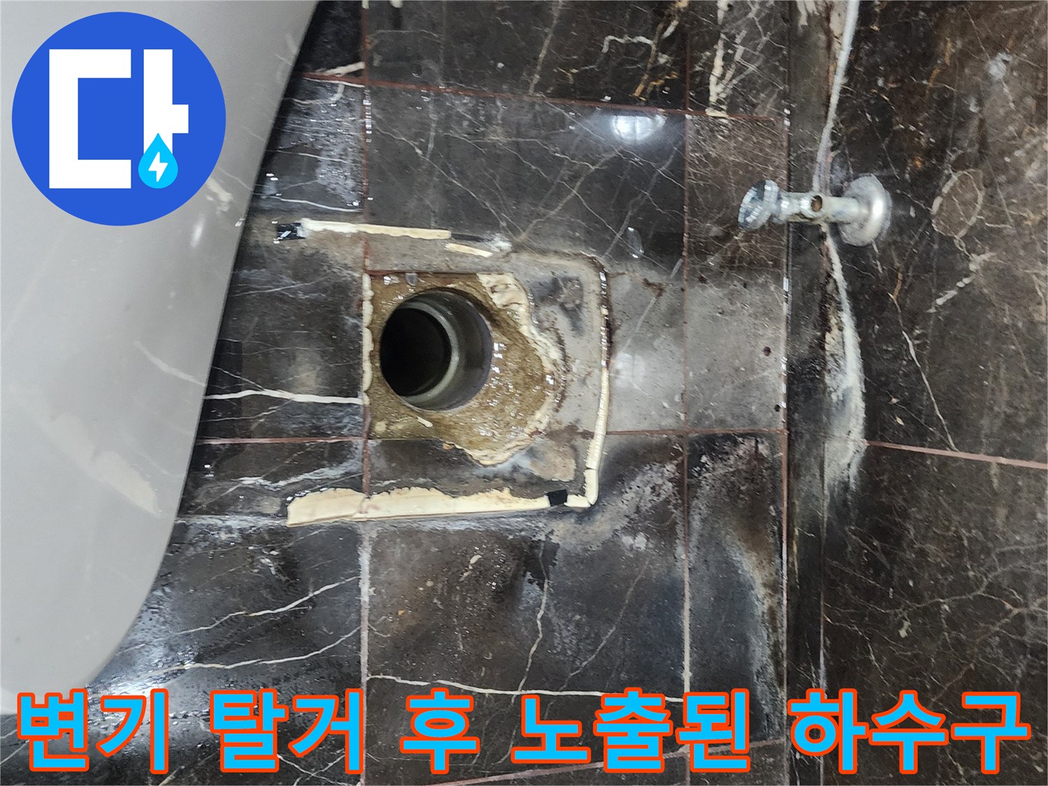 변기가 제거된 자리의 배관과 젖은 타일 표면 모습