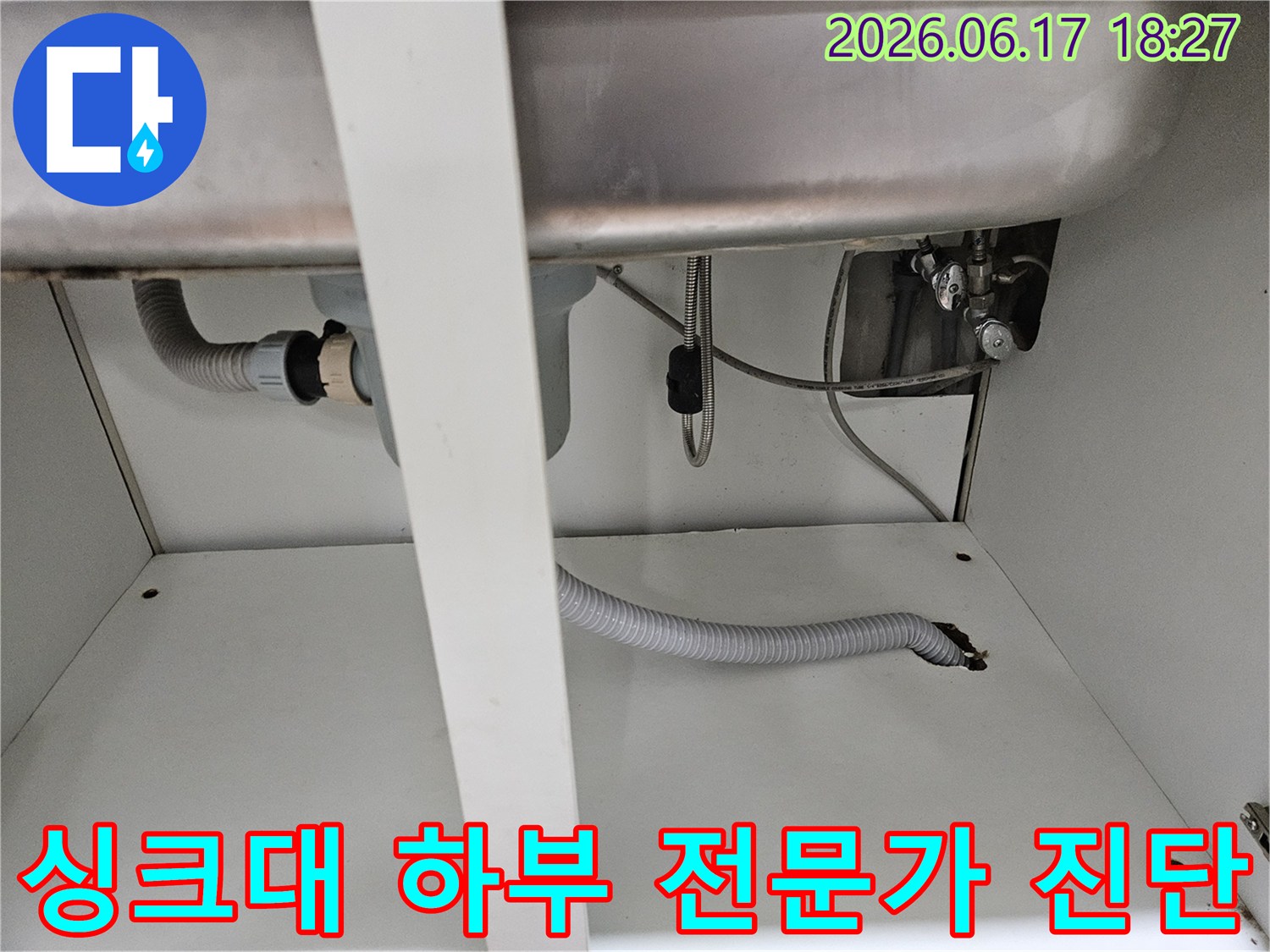 싱크대 하부의 복잡한 배관 시스템에서-전문가가 누수 지점을 꼼꼼하게 진단하는 현장 사진입니다