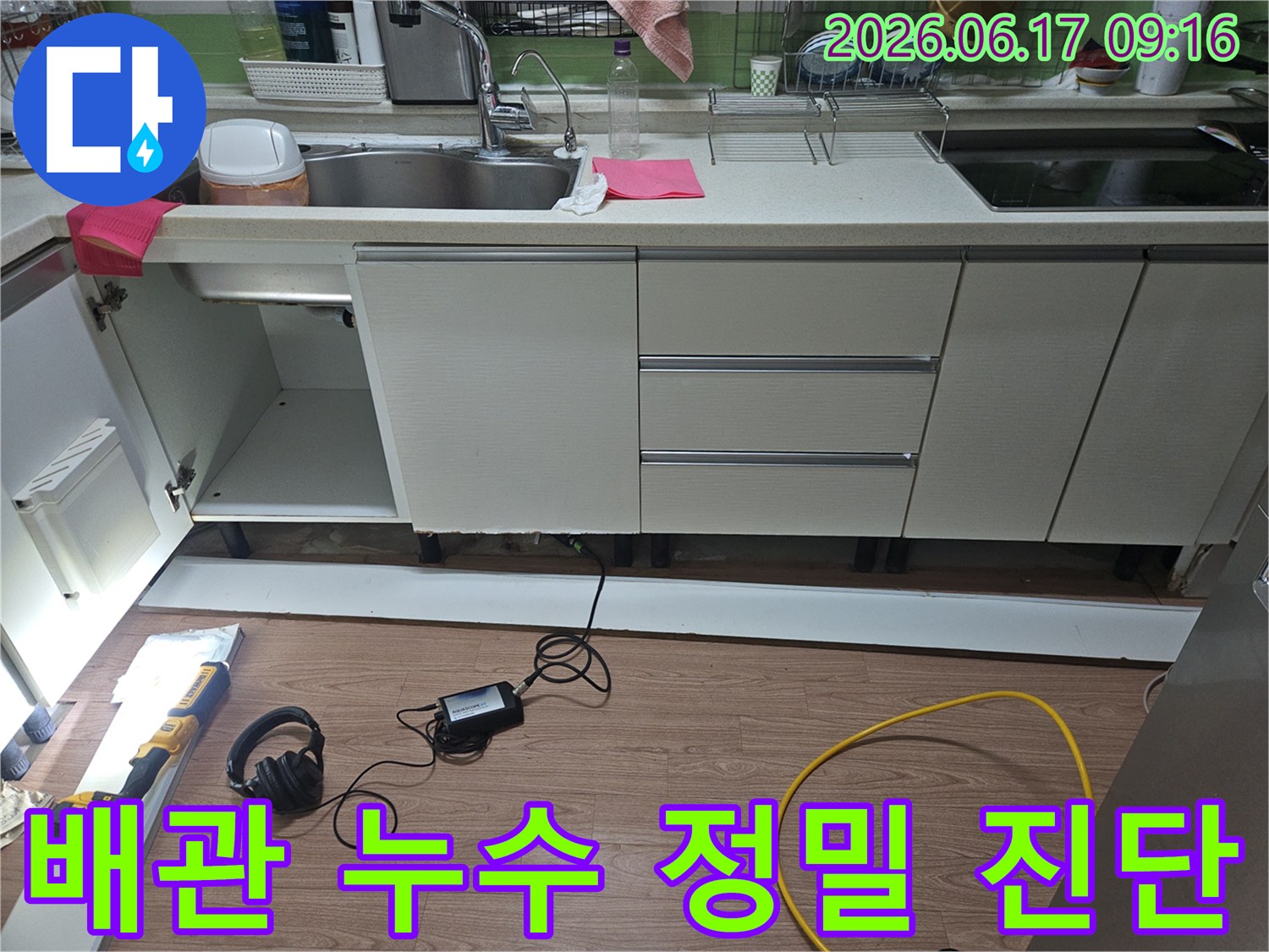주방 하수관 누수 현장에서-정밀 검사를 진행하기 위해-전문 장비를 사용하여-싱크대 하부 배관을-꼼꼼히 확인하는 모습