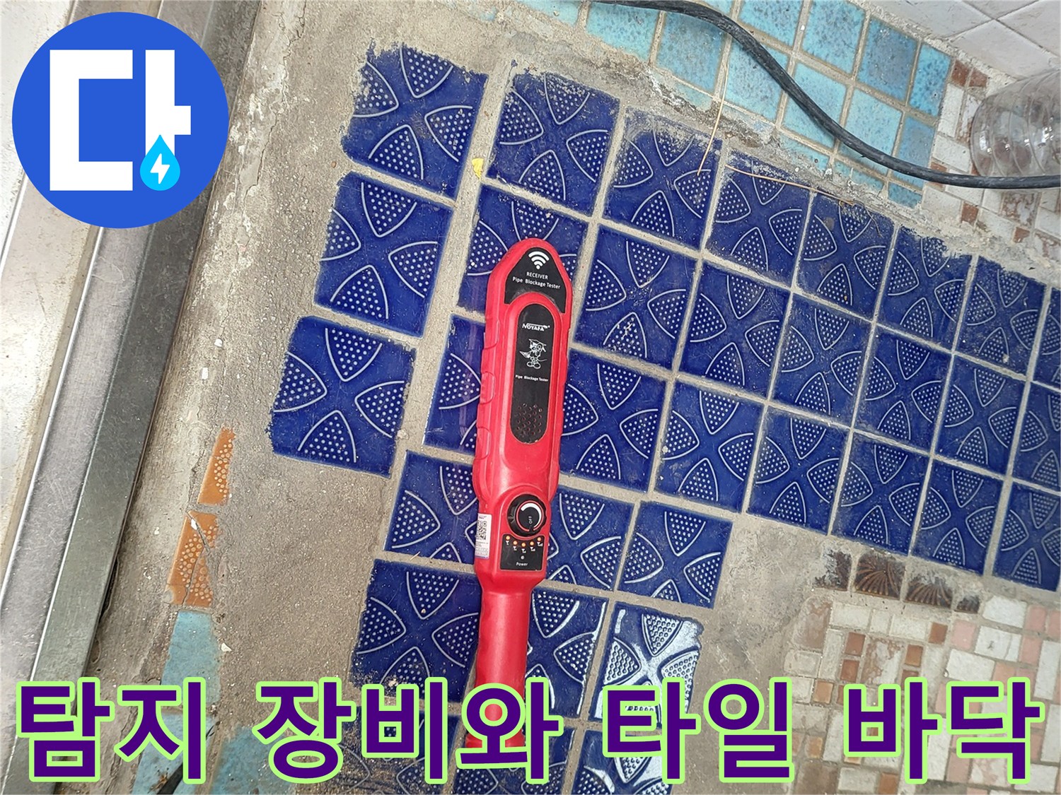 파란색 무늬 타일 위에 놓인 빨간색 정밀 탐지 도구