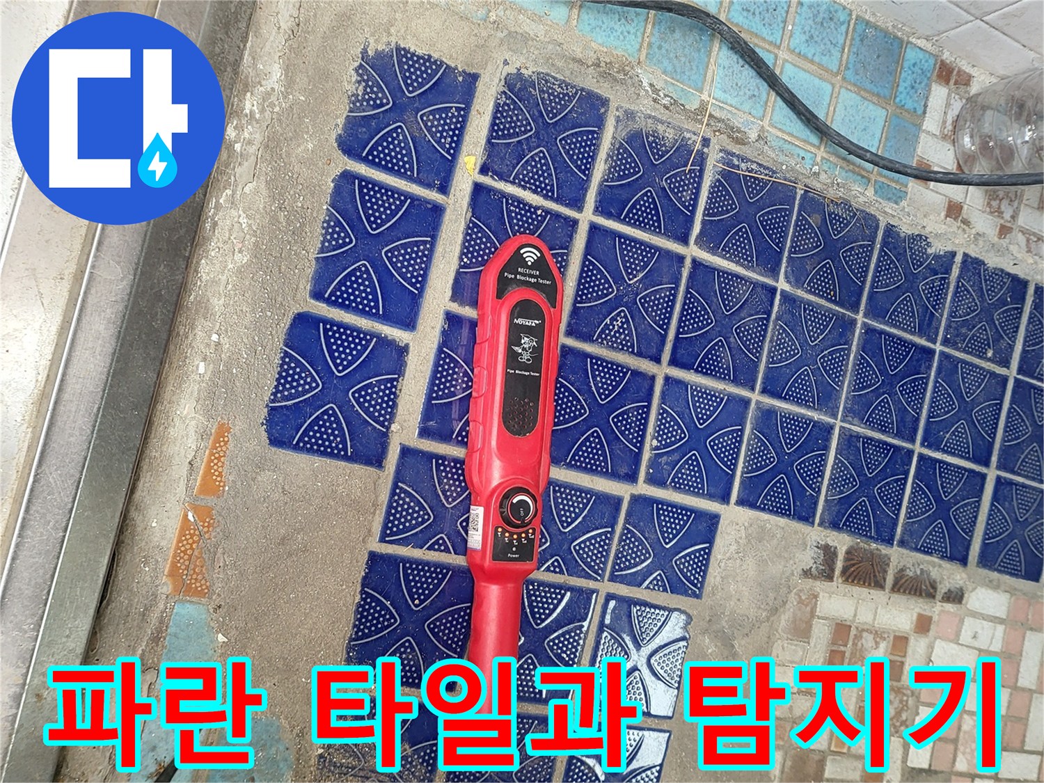 푸른색 패턴 타일 위에 놓인 붉은색 가스 탐지기