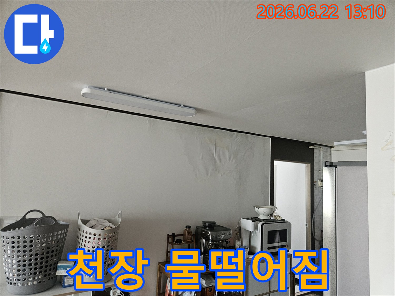 물에 젖어 얼룩지고 손상된 벽면과-그 위로 보이는 천장의 모습에서 누수의 심각성을 짐작할 수 있는 사진입니다.