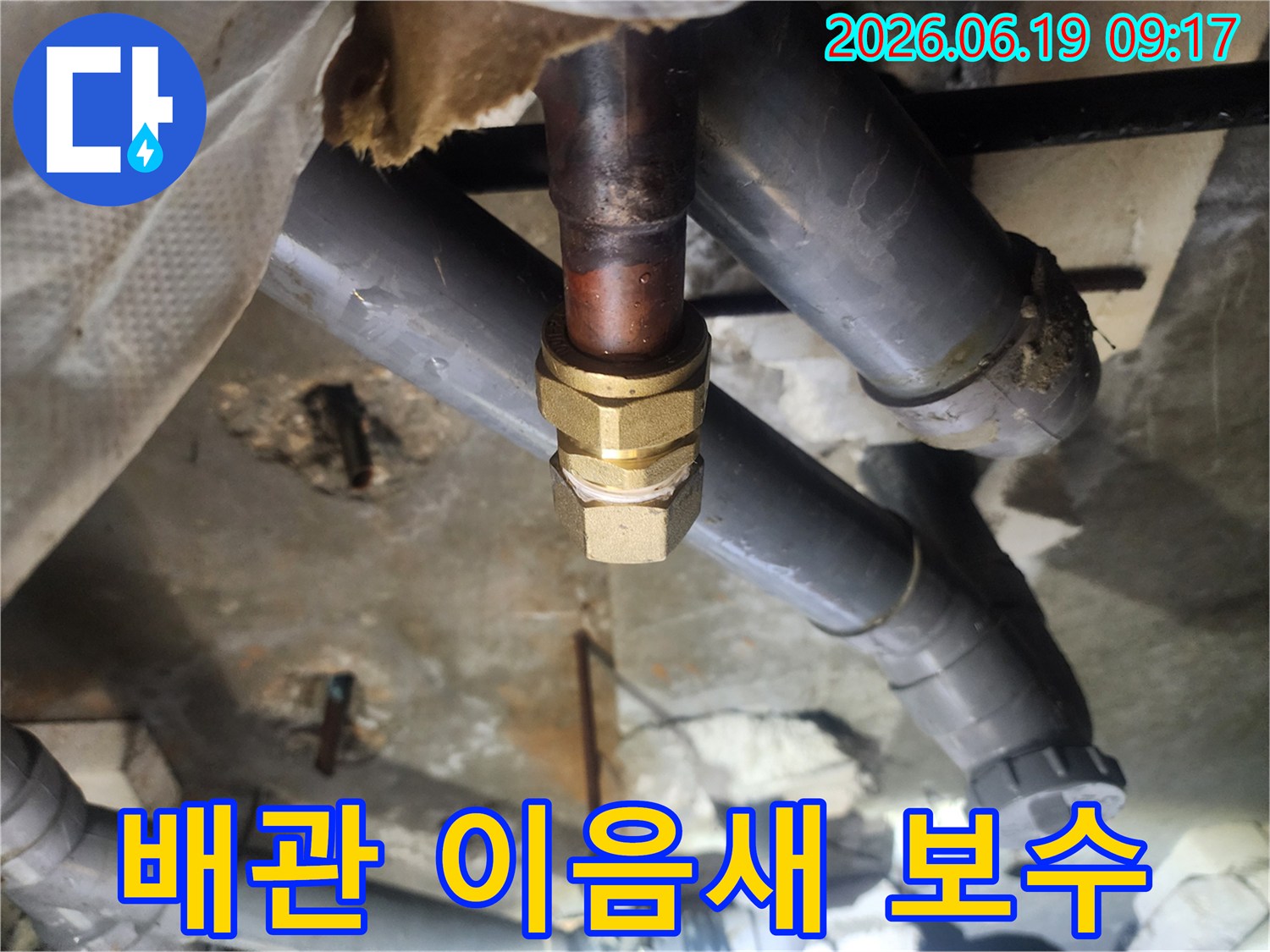 이 이미지는-천장 속-오래된 동관의-손상된 이음새를-새로운 황동 부품으로-교체하여-누수를-해결하는-전문적인-수리 현장입니다.