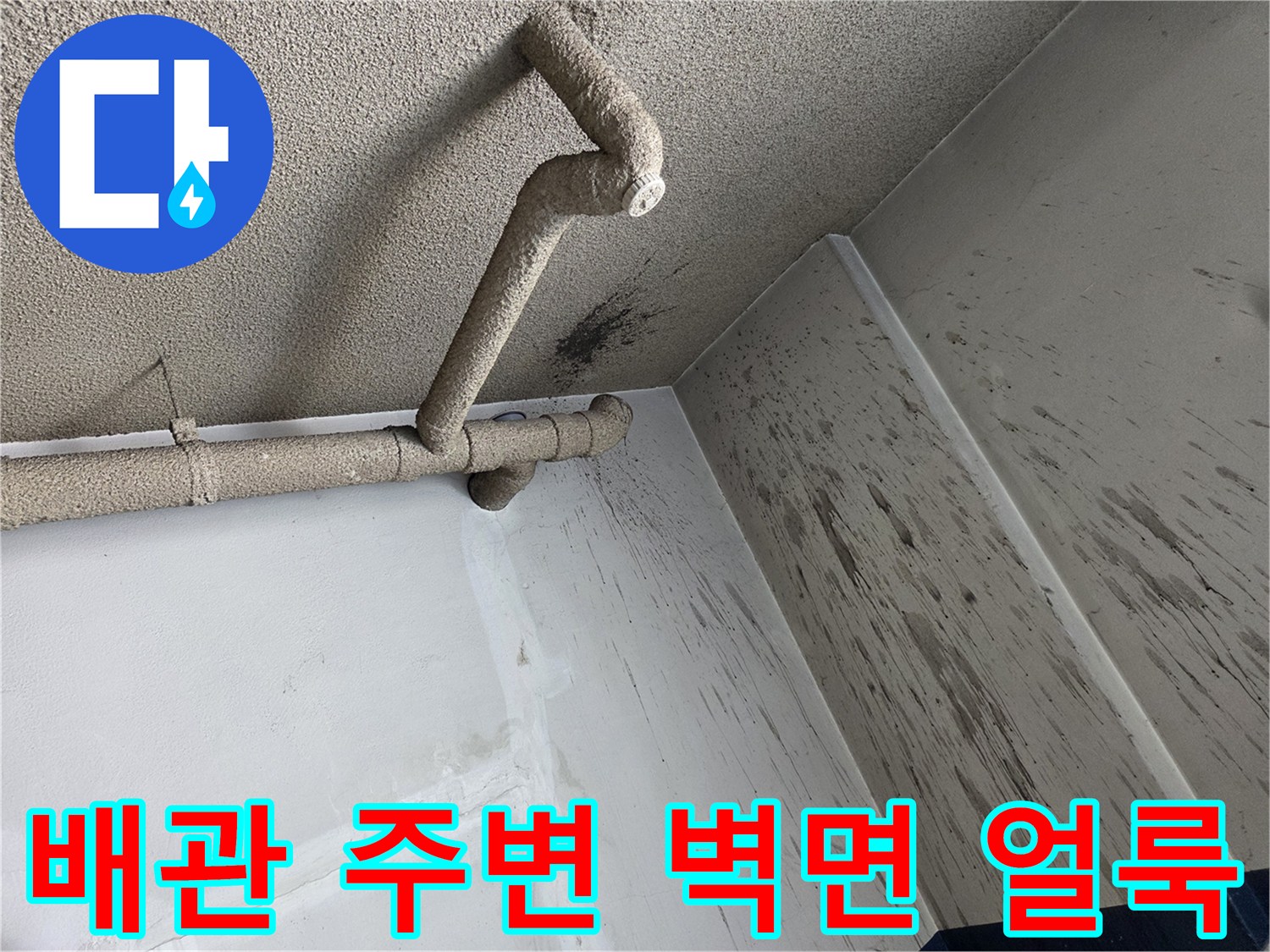 천장 배관과 연결된 벽면의 검은 오염물 사진입니다.
