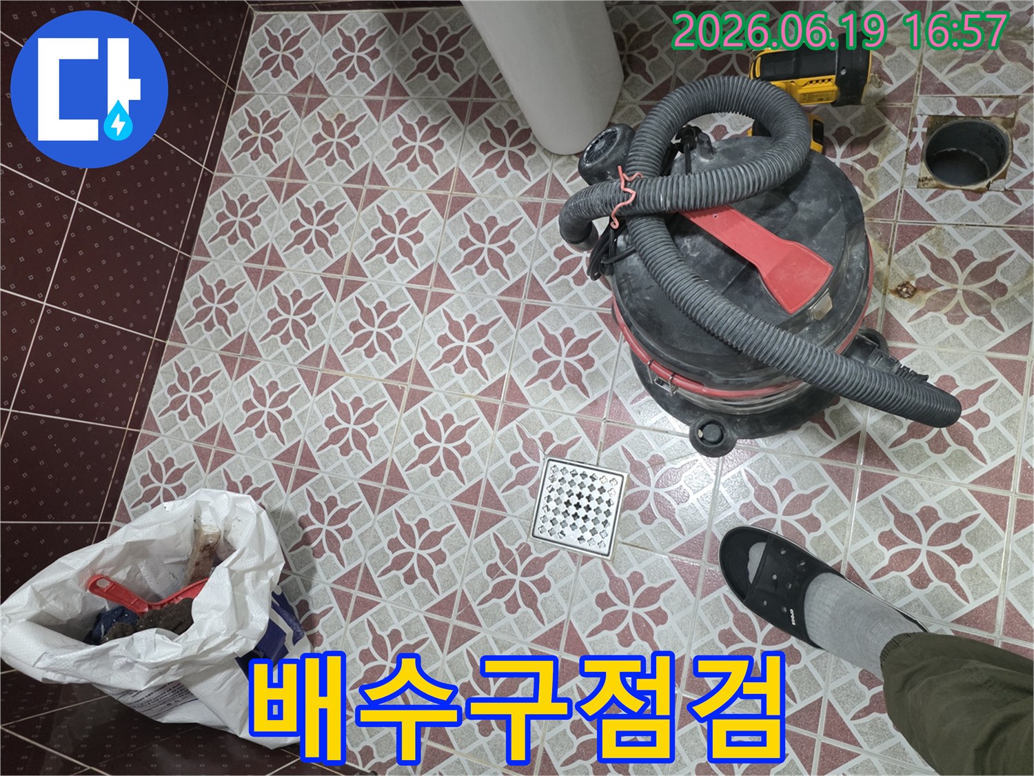 누수 문제 해결을 위한-욕실 바닥 작업 현장-습식 청소기로 물을 빨아들이고-배수구를 중심으로-정돈된 모습