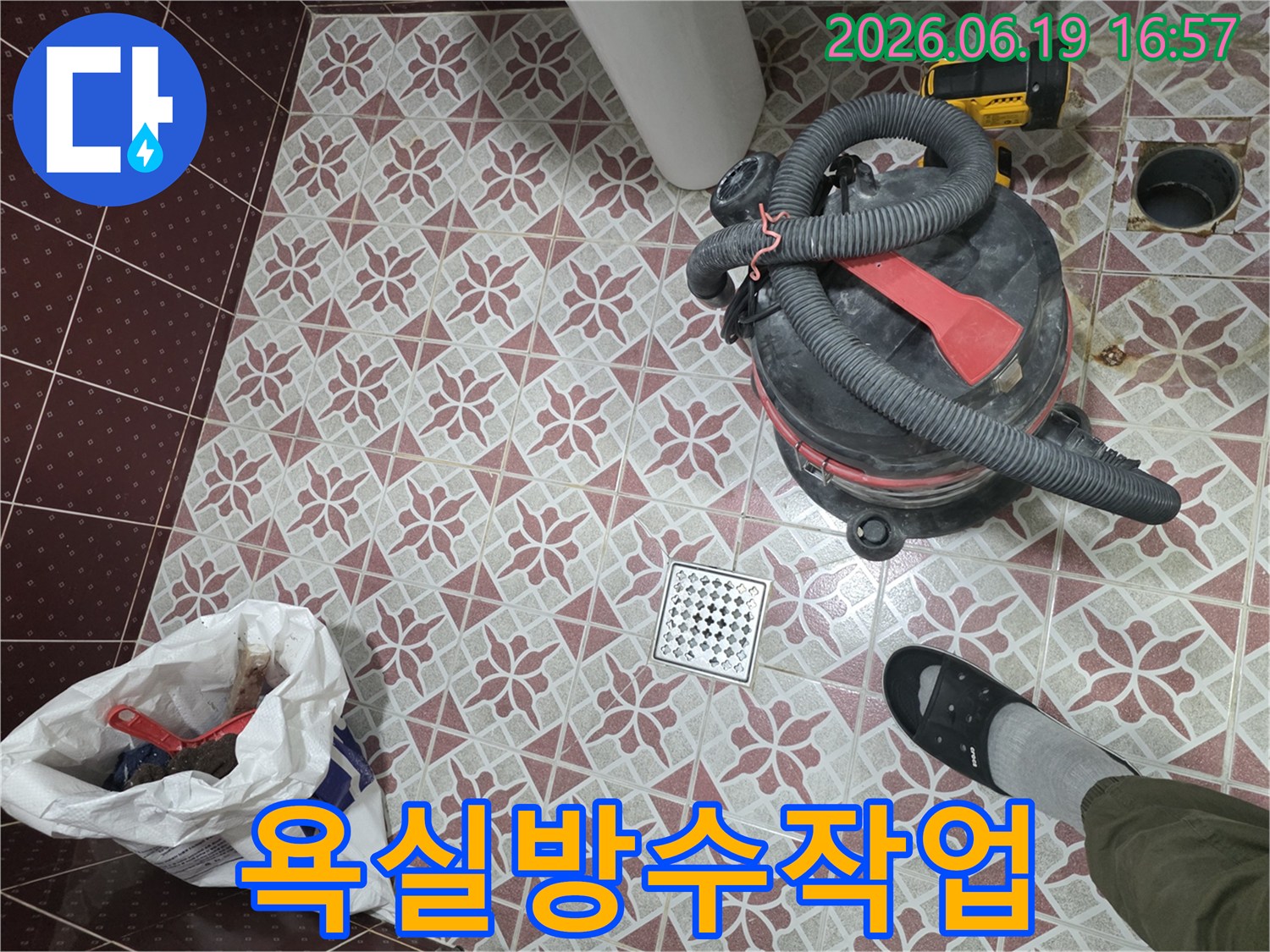 누수 공사 중-발생한 물기를 제거하고-바닥을 청결하게 유지하는 과정입니다-습식 청소기를 통해-배수구 주변의 물기를 흡입하여-건조 상태를 확보하고 있으며-이는 고객님의 만족도를 높이기 위한-필수적인 작업입니다