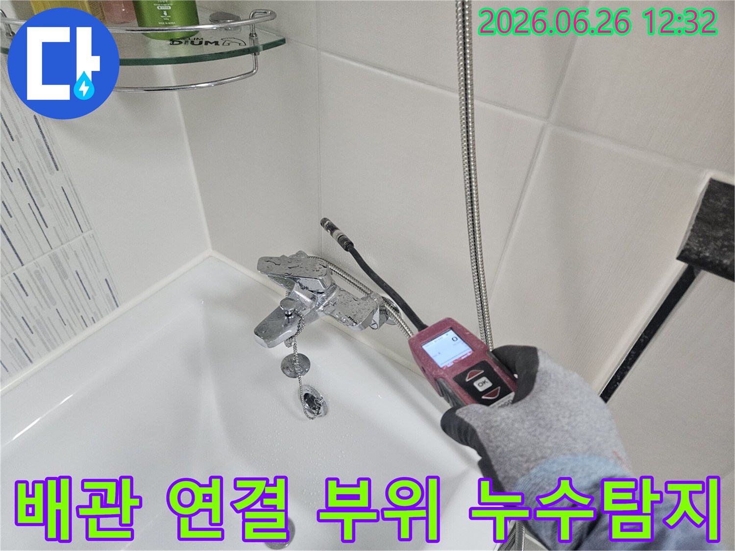 전문가가 샤워실 배관 연결 부위의 누수 여부를 첨단 장비로 확인하는 모습