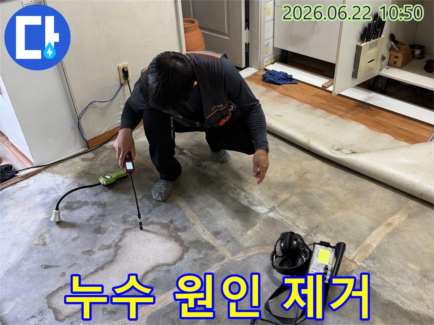 누수-탐지-전문가가-정밀-탐지기로-누수-지점을-확인한-후-원인-제거를-위한-공사-계획을-세우는-모습