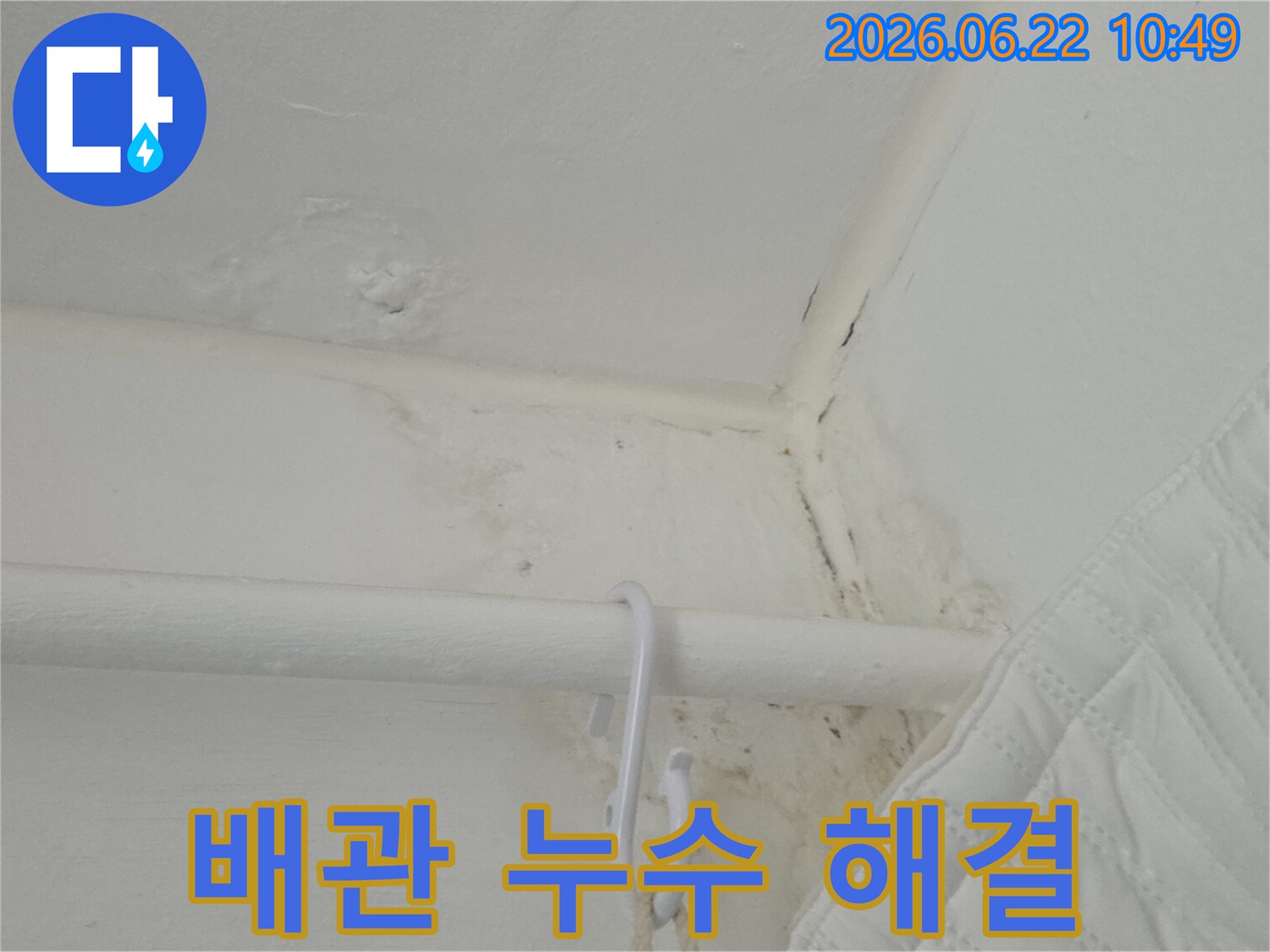 천장-모서리와-흰색-배관-주변에-생긴-물-얼룩과-곰팡이를-담은-사진입니다