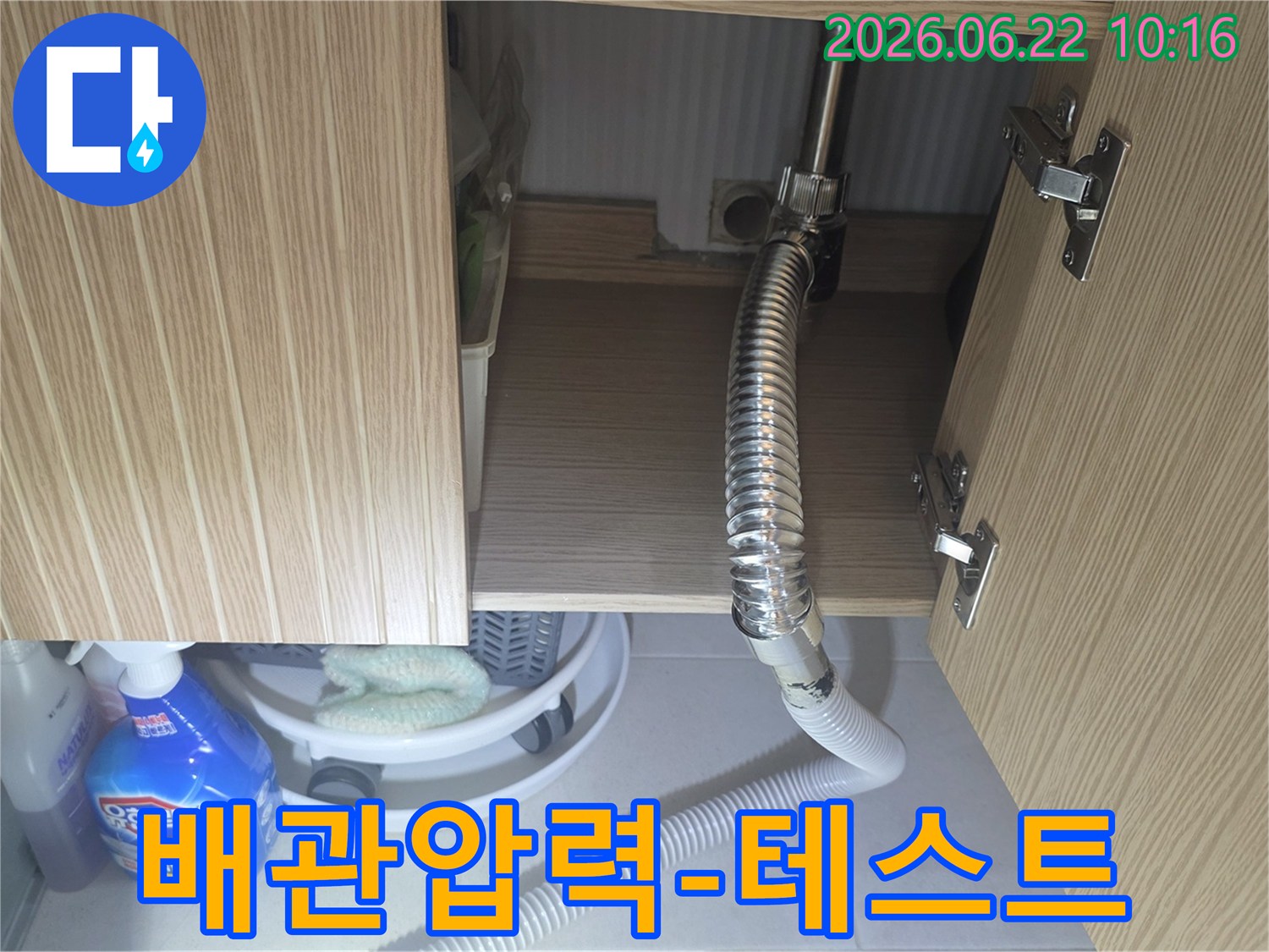싱크대 하부 배관의 압력 상태를 점검하고-누수 여부를 확인하기 위한 테스트를 진행하는 모습