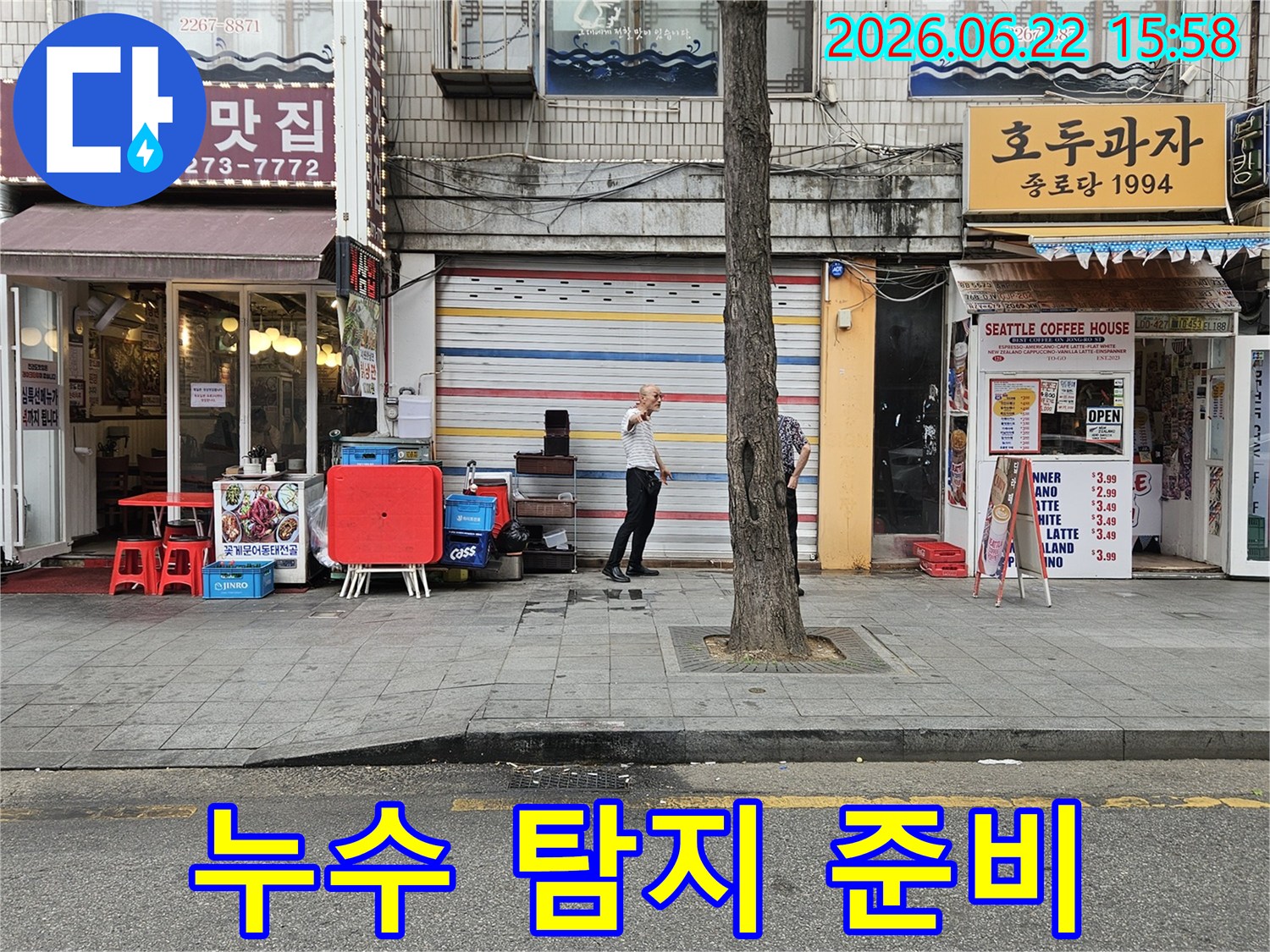 서울-종로구-수표로-지역의-상가-건물-앞에서-누수-전문가가-현장-상황을-파악하며-누수-탐지를-위한-준비를-하는-모습입니다.