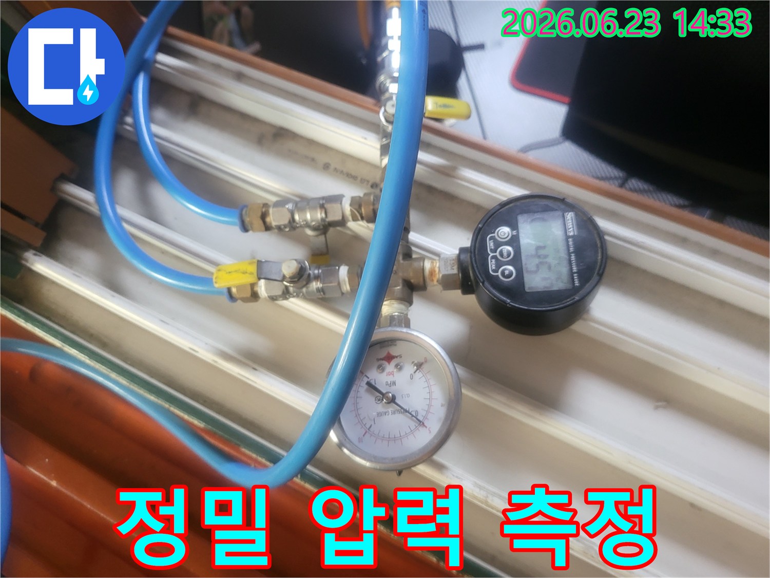 파란색 호스와-다양한 밸브-그리고 압력계가 연결된-누수 탐지 장비가-작동 중인 모습입니다.