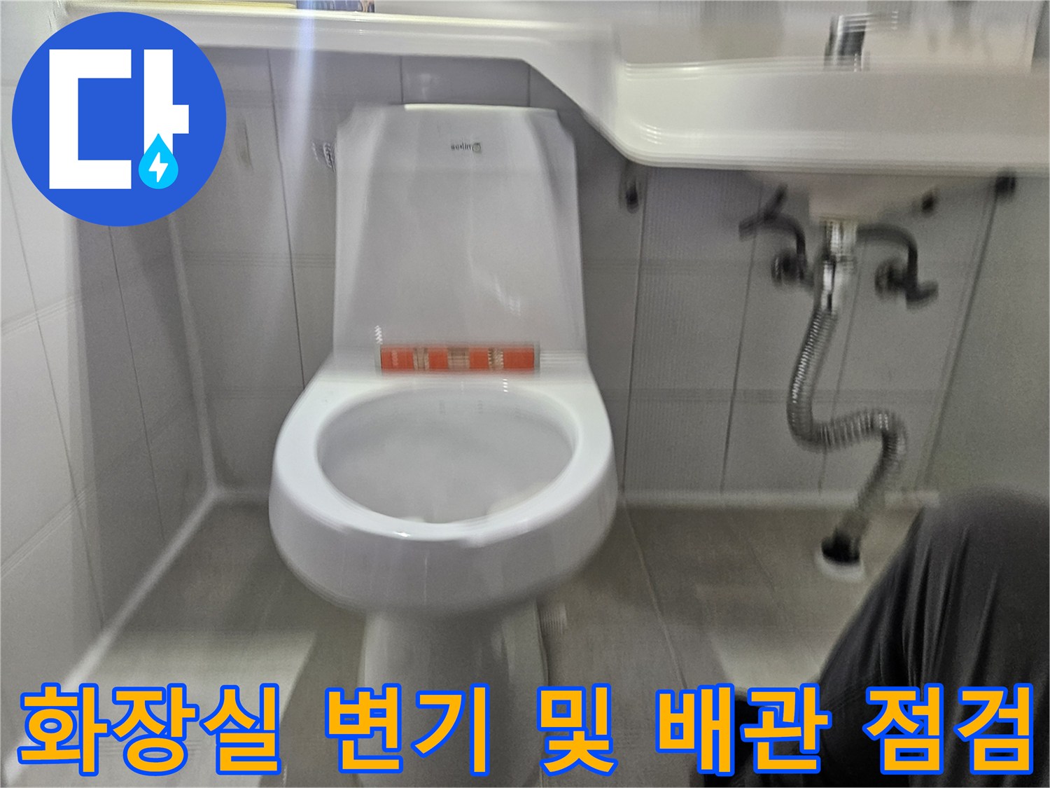 변기 하단과 세면대 아래 배수 호스가 노출된 모습