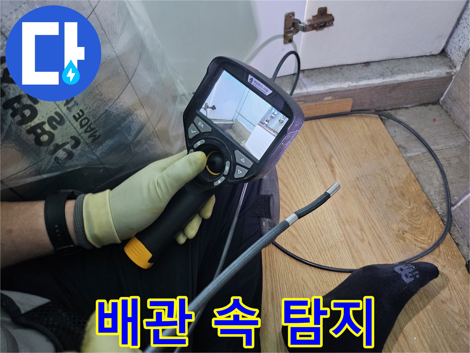 이 이미지는-숙련된 기술자가-누수 문제를 해결하고자-내시경 탐지기로-숨겨진 배관의 상태를 확인하는 과정입니다.