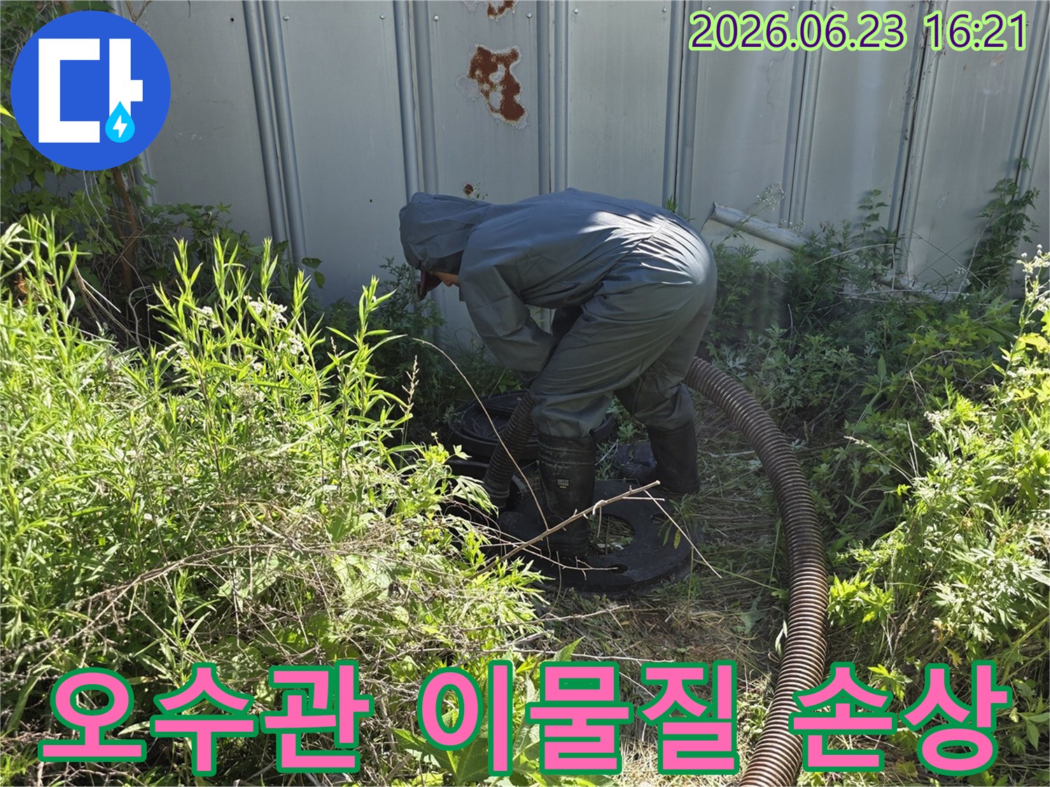 전문가가 보호복을 입고 오수관 내부의 이물질로 인한 배관 손상 여부를 확인하기 위해 흡입 작업을 하는 모습