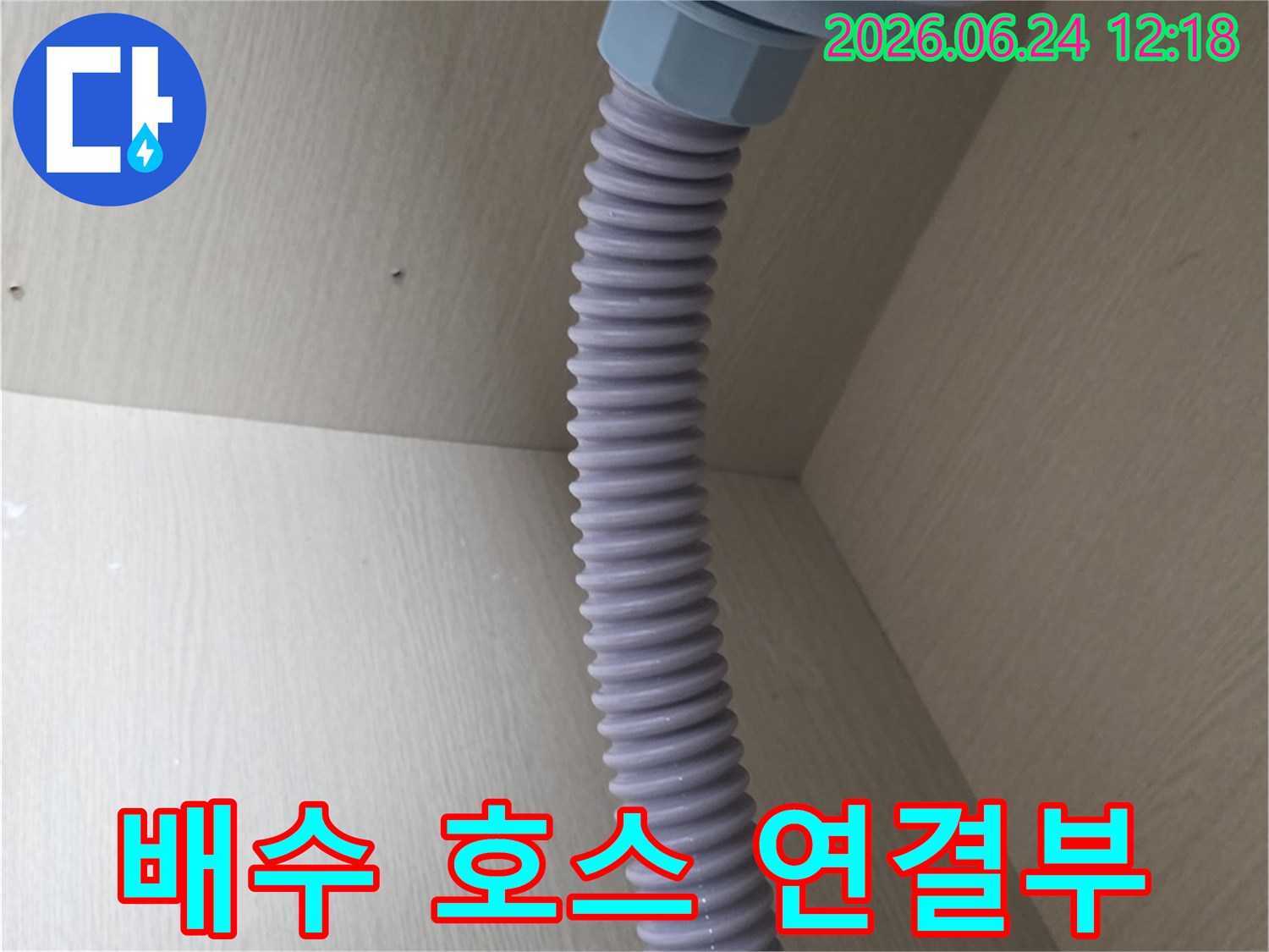 이 이미지는-싱크대 하부장에-설치된-배수 호스와-연결 장치의-모습을-보여줍니다.