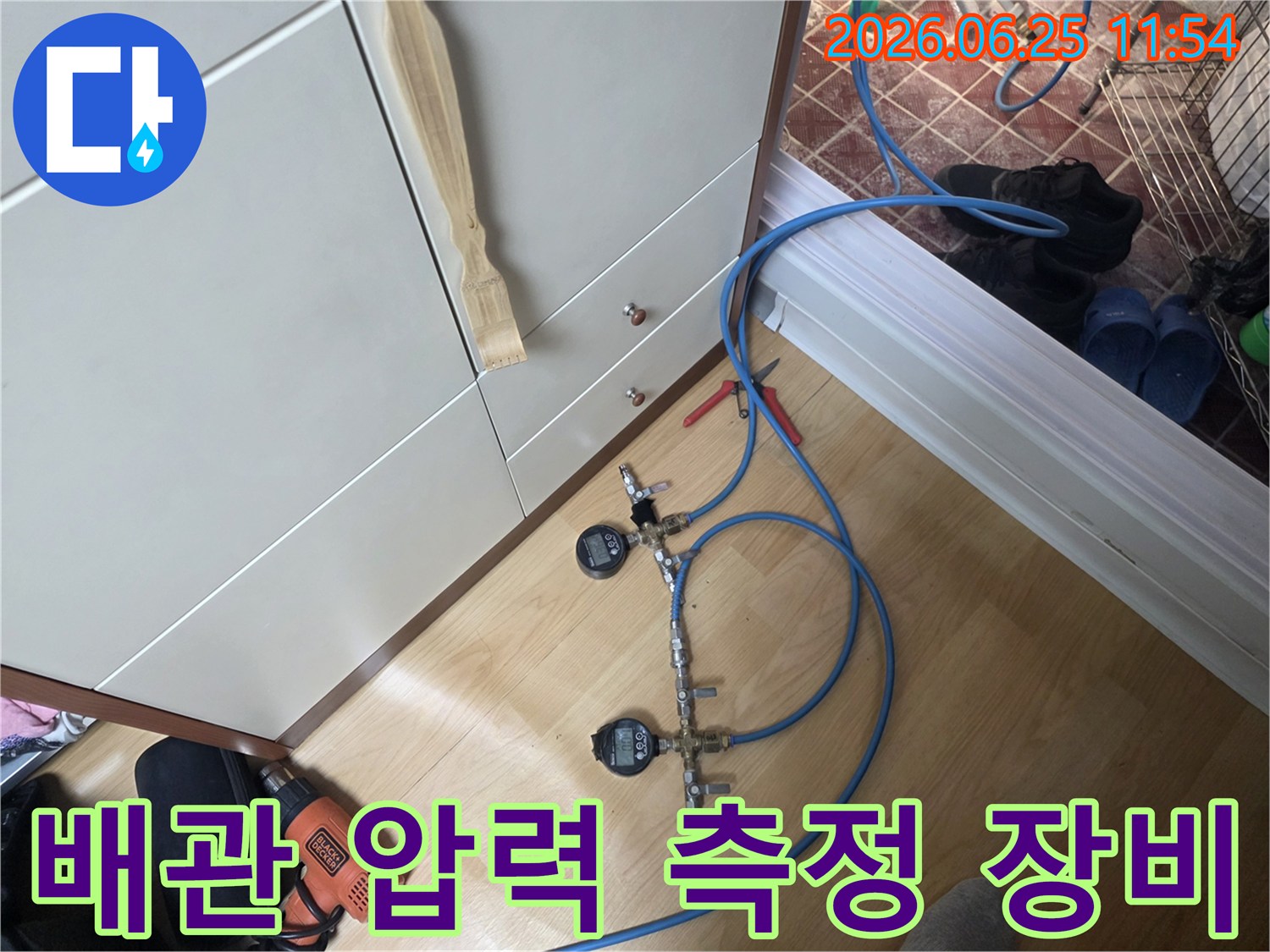누수 엔지니어가 배관의 압력을 세밀하게 모니터링하기 위해 디지털 압력 게이지가 연결된 가압 테스트 장치를 사용하고 있습니다