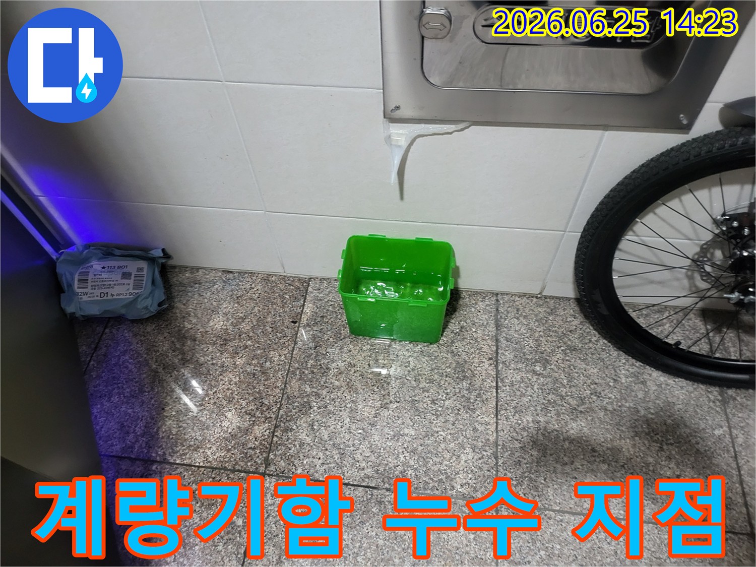 수도계량기함-아래에서-물이-새어-나와-초록색-물받이에-고이는-상황을-보여주는-누수-현장-사진