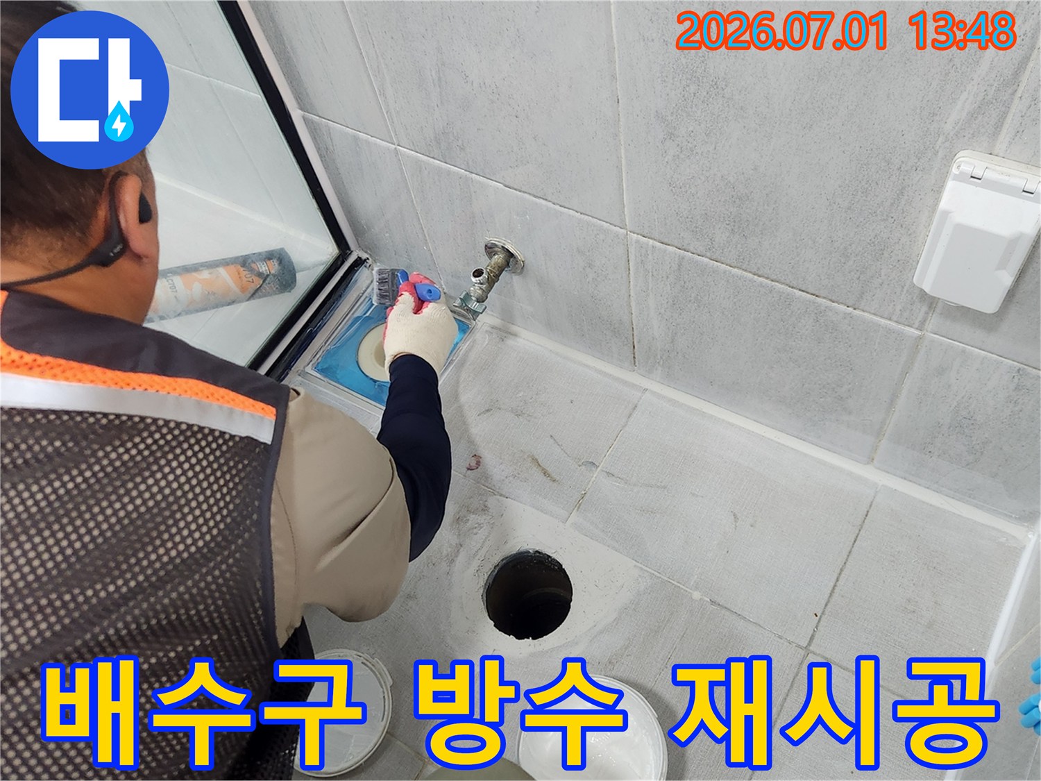 전문 기술자가-욕실 배수구 주변의-기존 방수층을 제거하고-새로운 방수층을-재시공하는 작업 현장