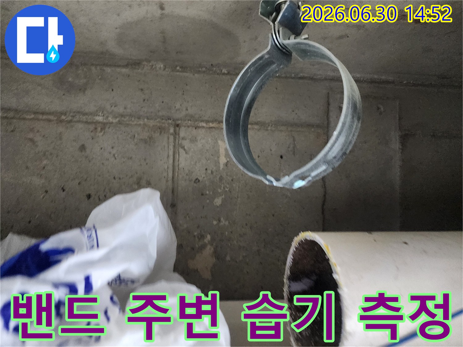 배관 고정 밴드 주변의-콘크리트 벽면에-습기가 스며든 모습을 보여주는-누수 현장 사진