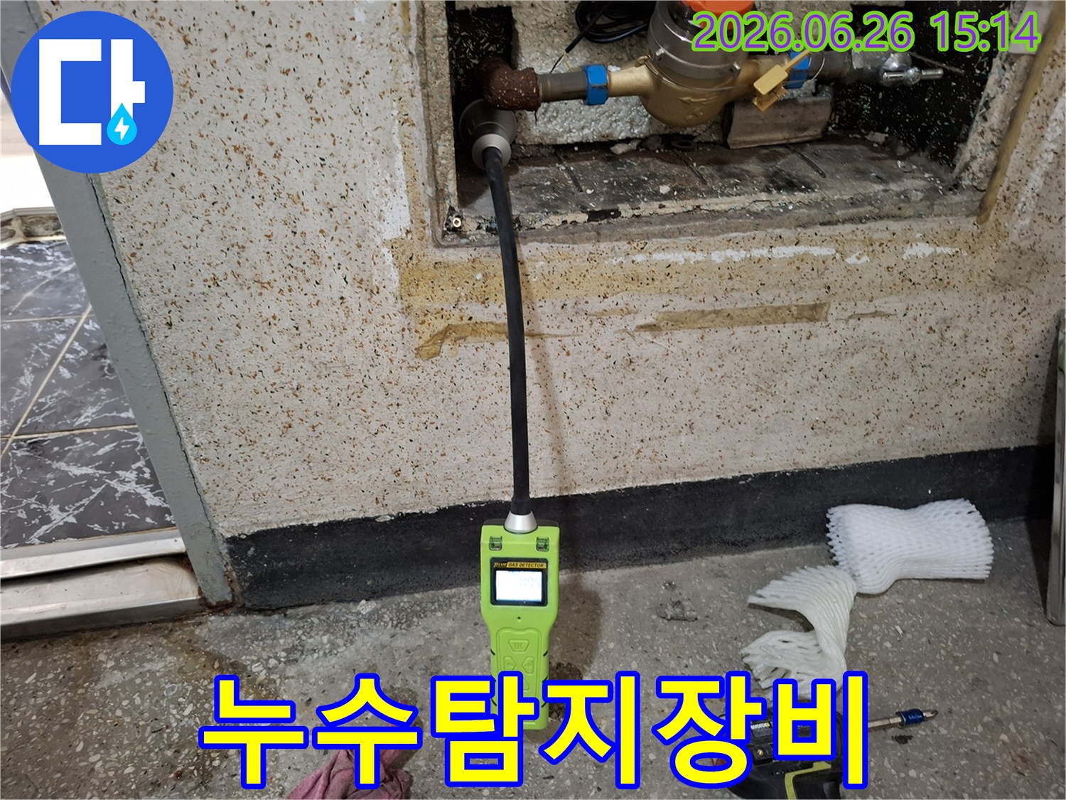 숨겨진 배관 누수를 정확히 찾아내기 위해 첨단 가스 탐지기로 탐지 작업을 진행하는 장면
