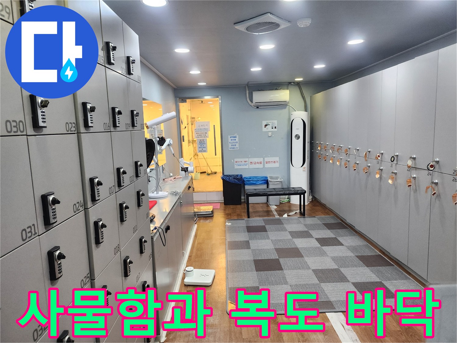 정돈된 사물함 뒤편으로 보이는 헬스장 내부 복도와 매트 공간입니다.