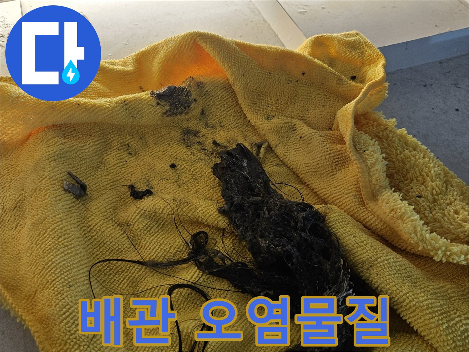 노란 수건 위에 떨어진 검은색 배관 찌꺼기들