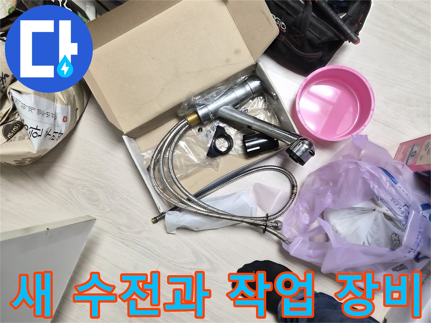 교체 작업을 위해 바닥에 놓인 새 싱크 수전과 각종 공구들