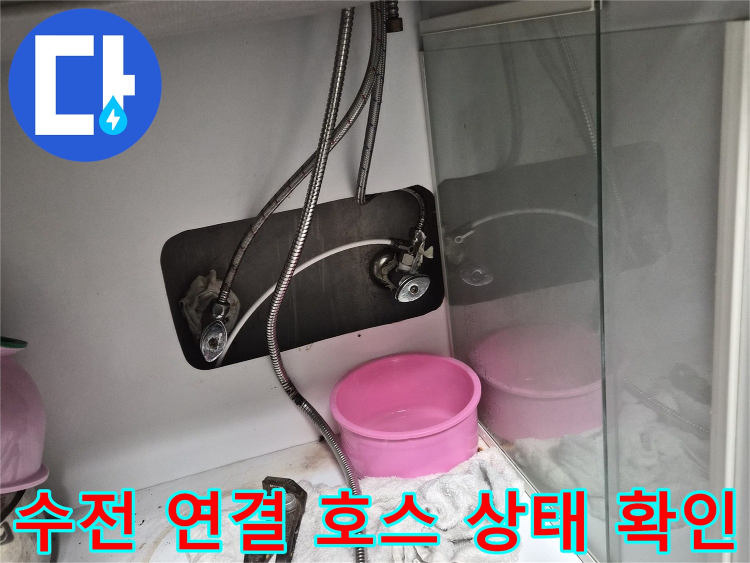 싱크대 아래쪽 수도 배관과 작업용 공구 배치 모습