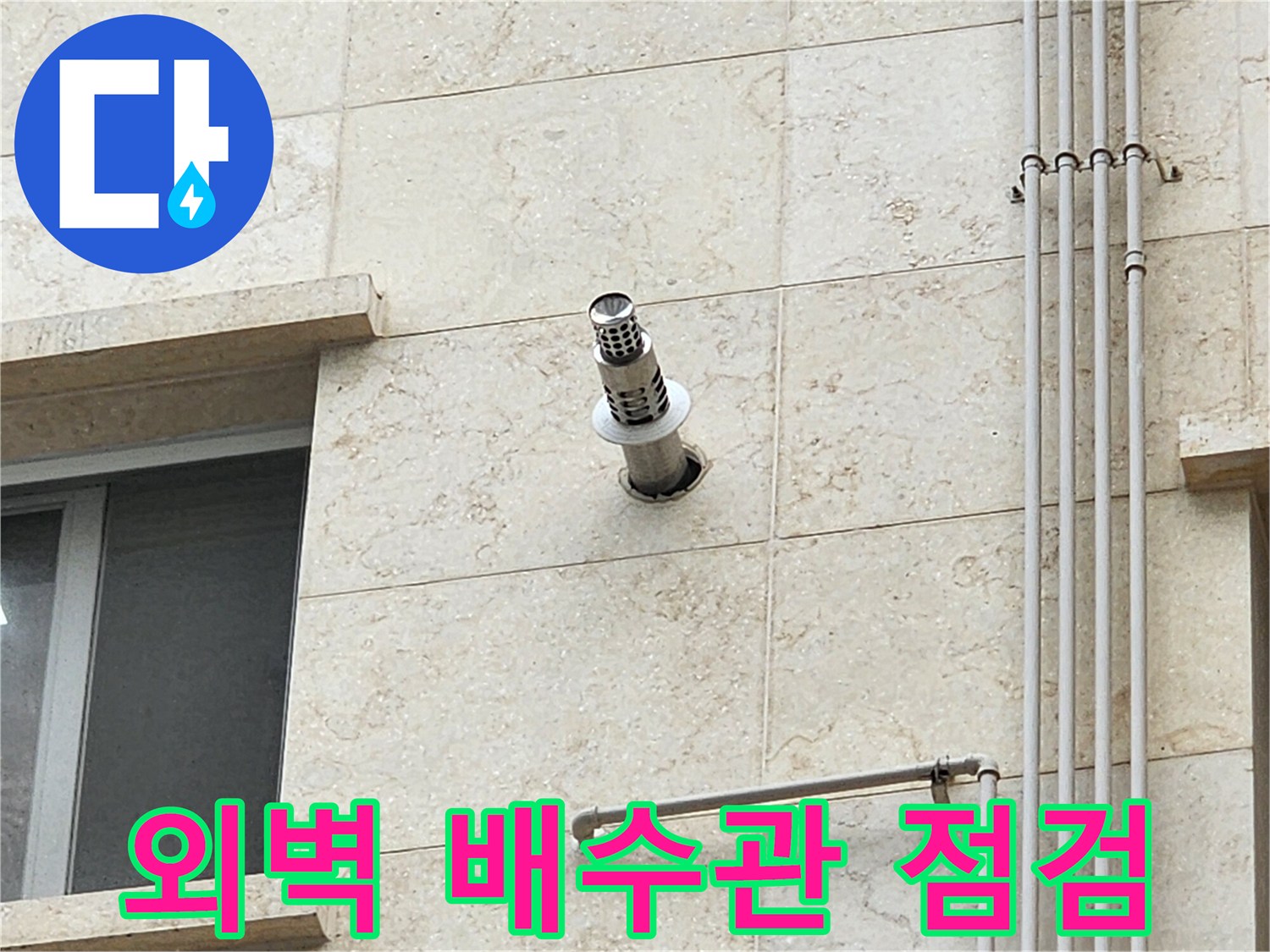 석재 외벽에 설치된 스테인리스 배수관과 주변 마감 상태