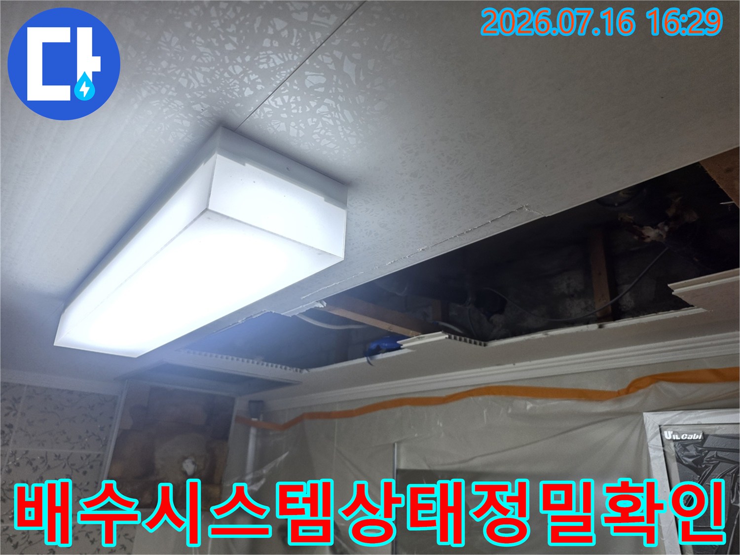 화장실 천장 내부 공간에서 배수 및 오수 관련 시설물을 점검하는 장면