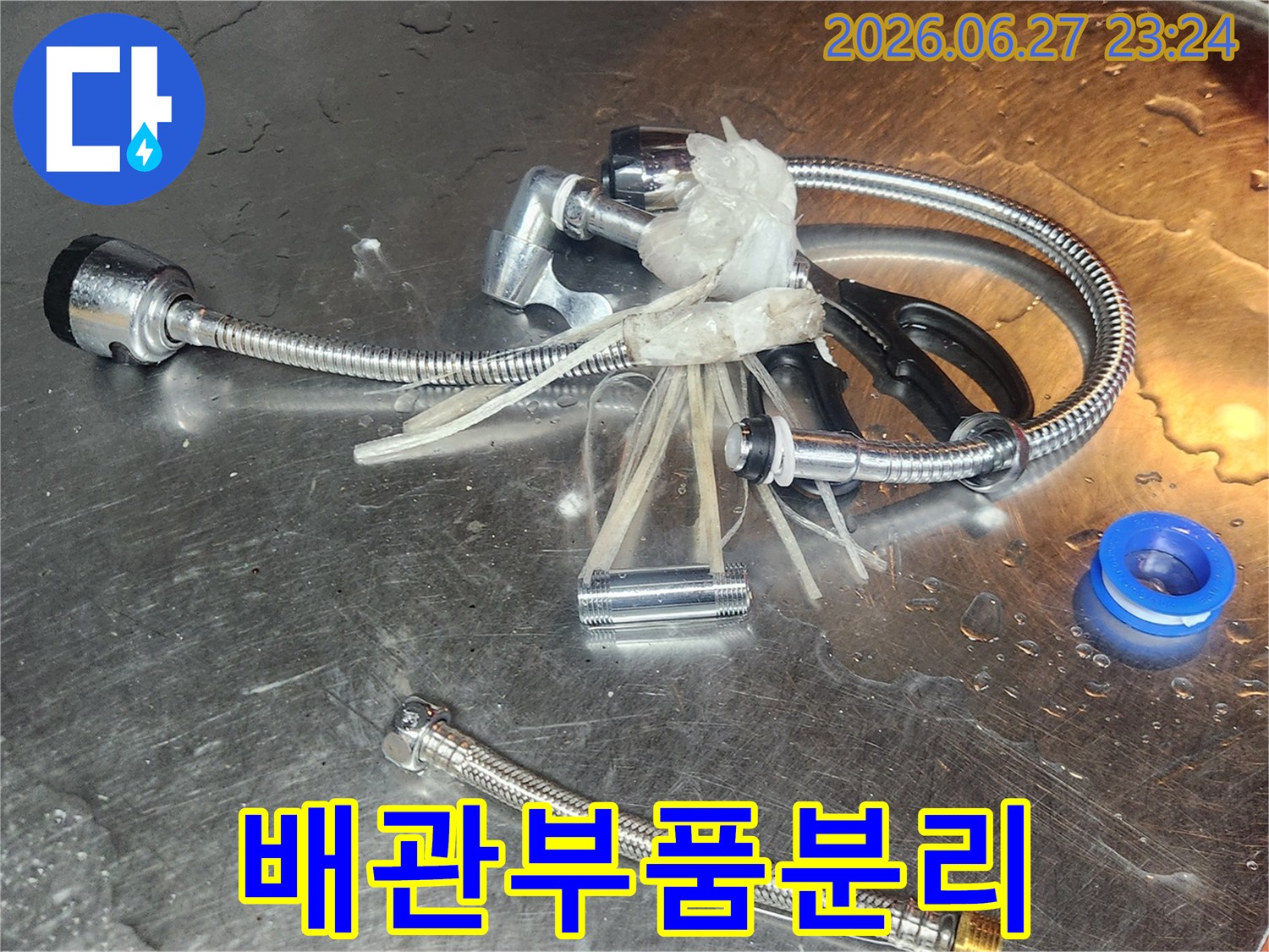누수-원인 파악을-위해-분리된-수도 밸브와-연결 부품들이-작업대 위에-놓여있습니다.