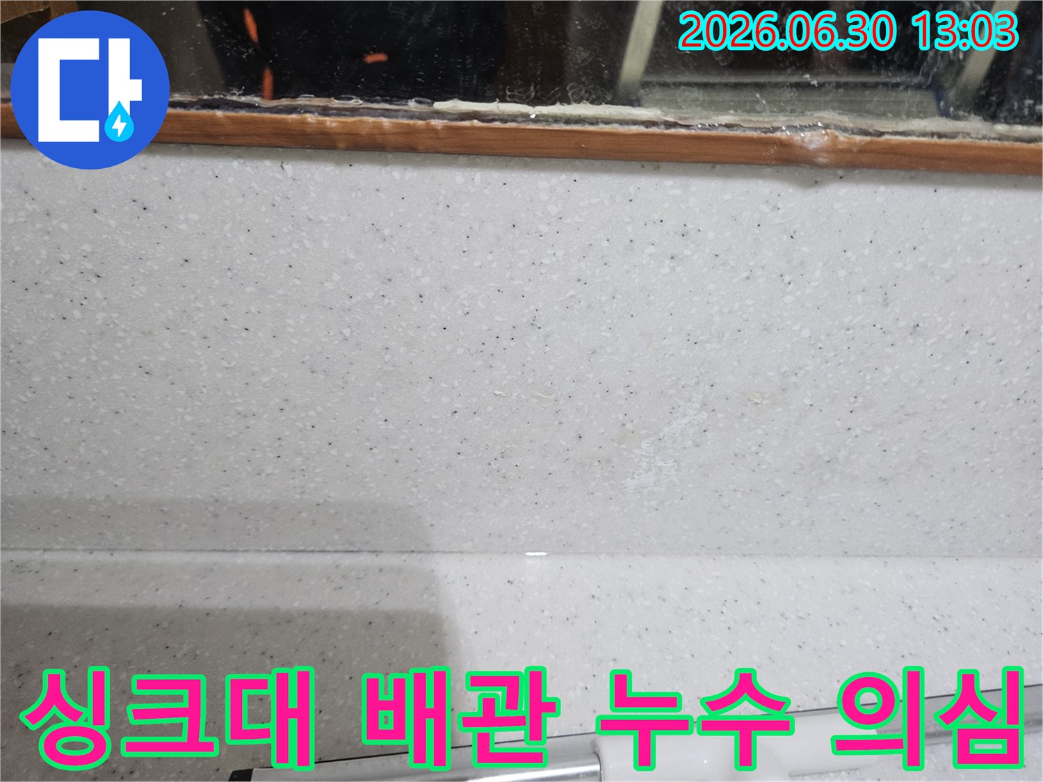 싱크대 주변-벽면에서-발견된-미세한 물자국을 통해-배관 누수를 의심하고-정밀 탐지를 준비하는 장면