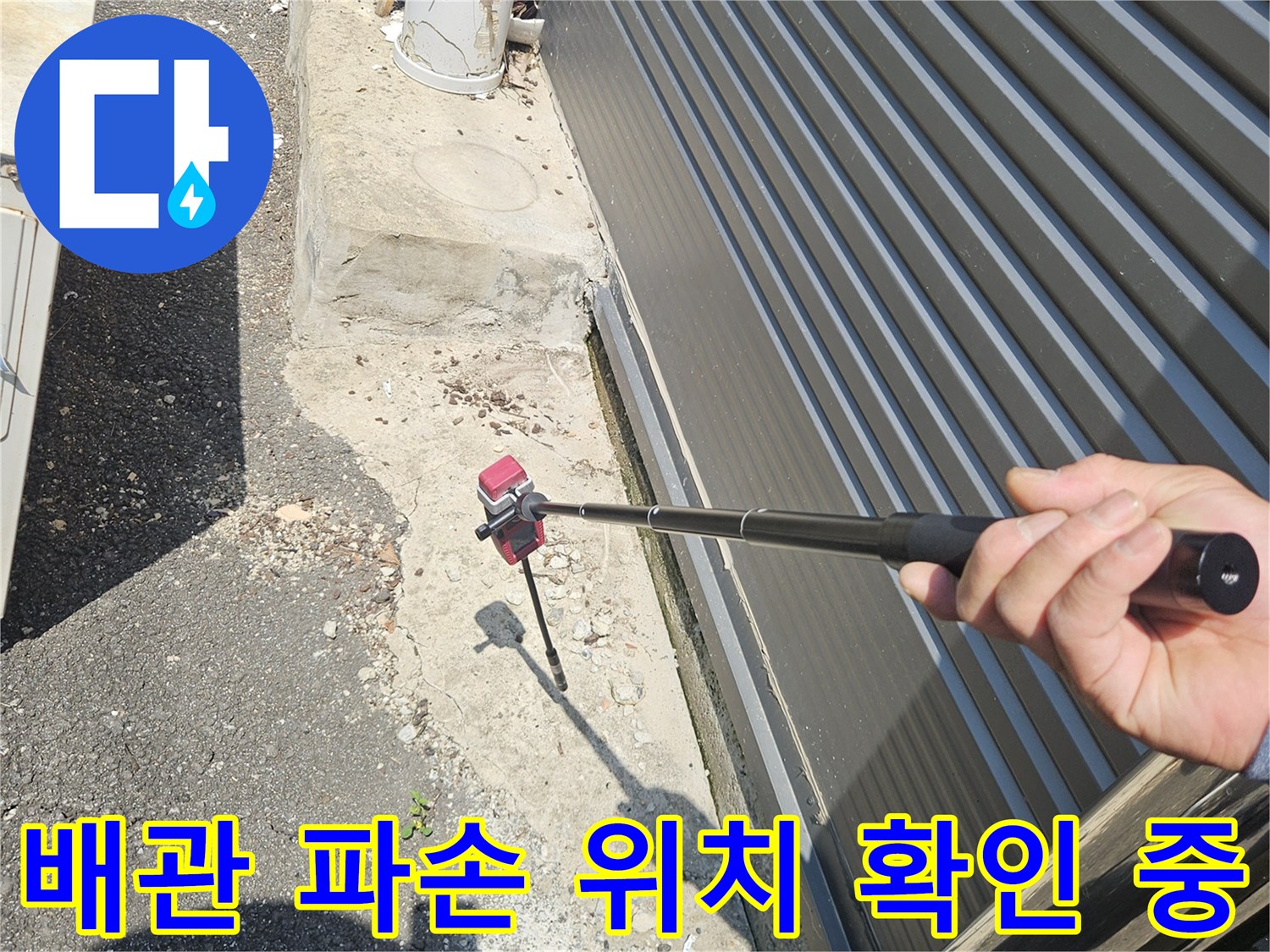 현장 진단 모습-맨홀 옆 배관의 누수 예상 지점을 탐지봉으로 가리킴