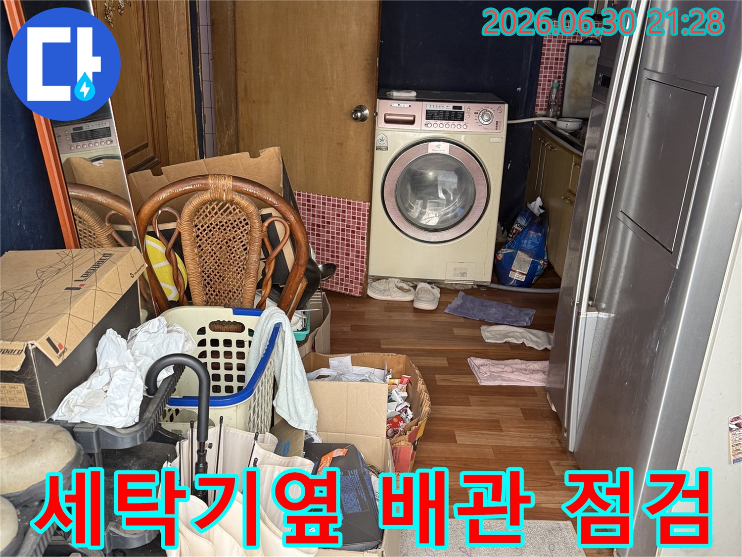 다용도실 세탁기 옆 공간에서 배관 및 주변 시설을 정밀하게 점검하는 모습