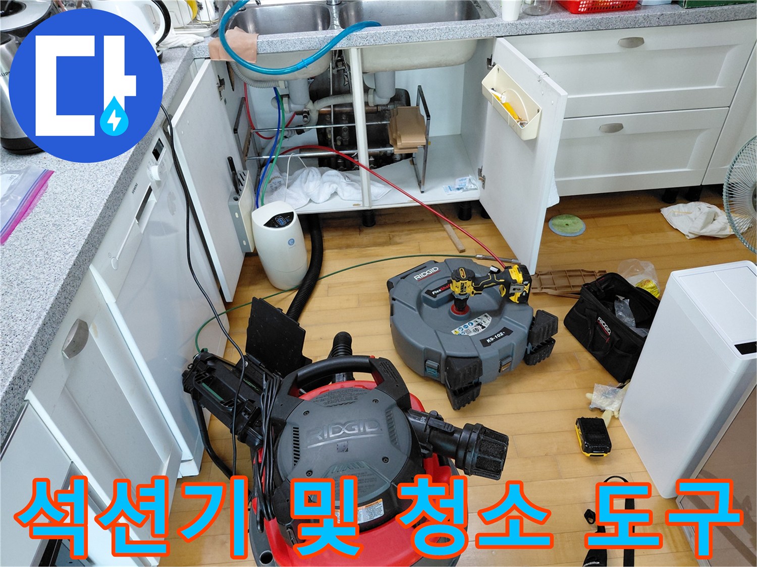 작업 현장-싱크대 밑 공간에 놓인 석션 장비와 공구함