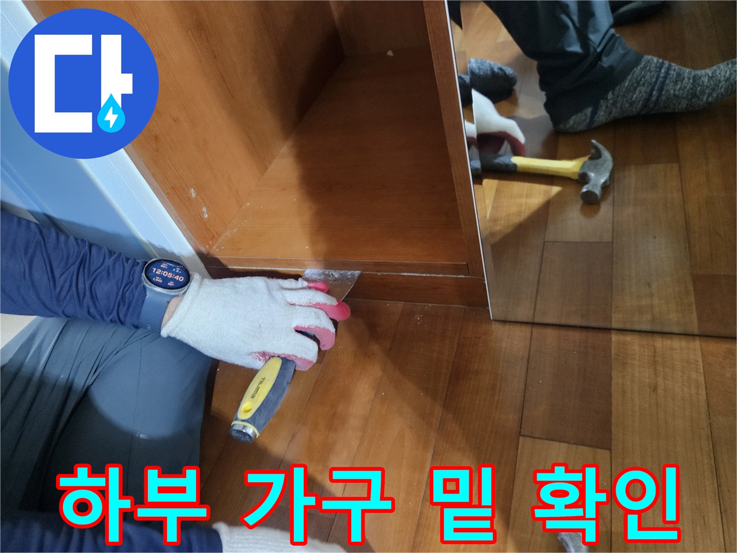 가구 하단 마감 부위의 누수 여부를 점검하는 작업자의 손과 도구