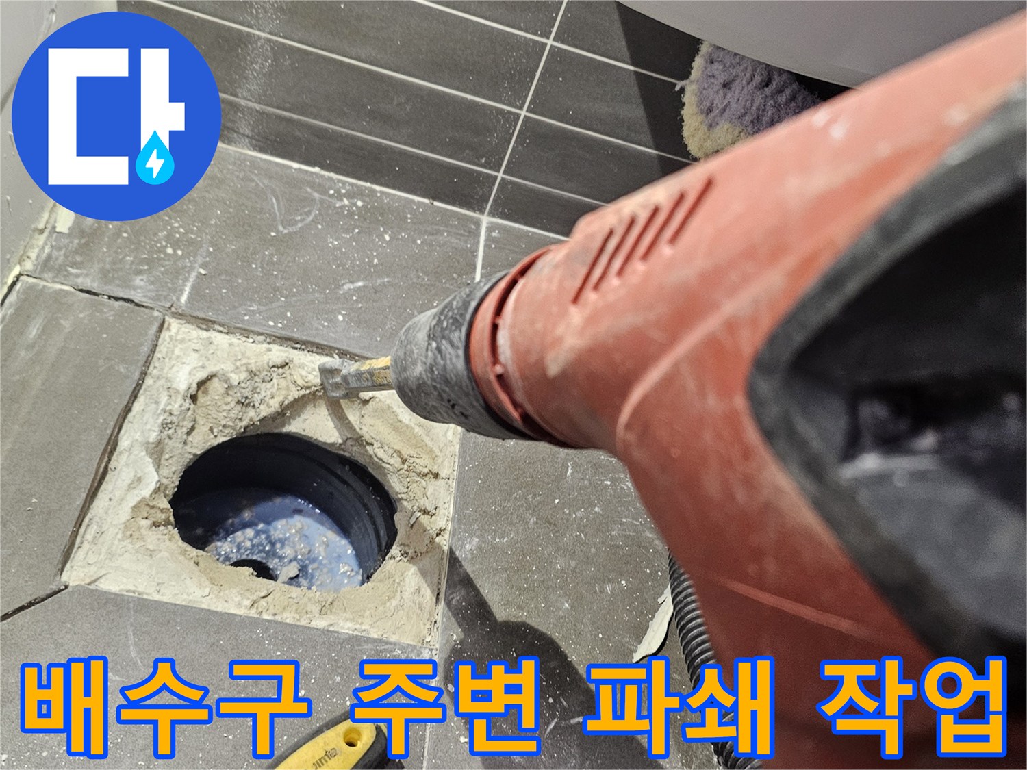 전동 드릴로-배수구 주변 타일을-파쇄하는 모습