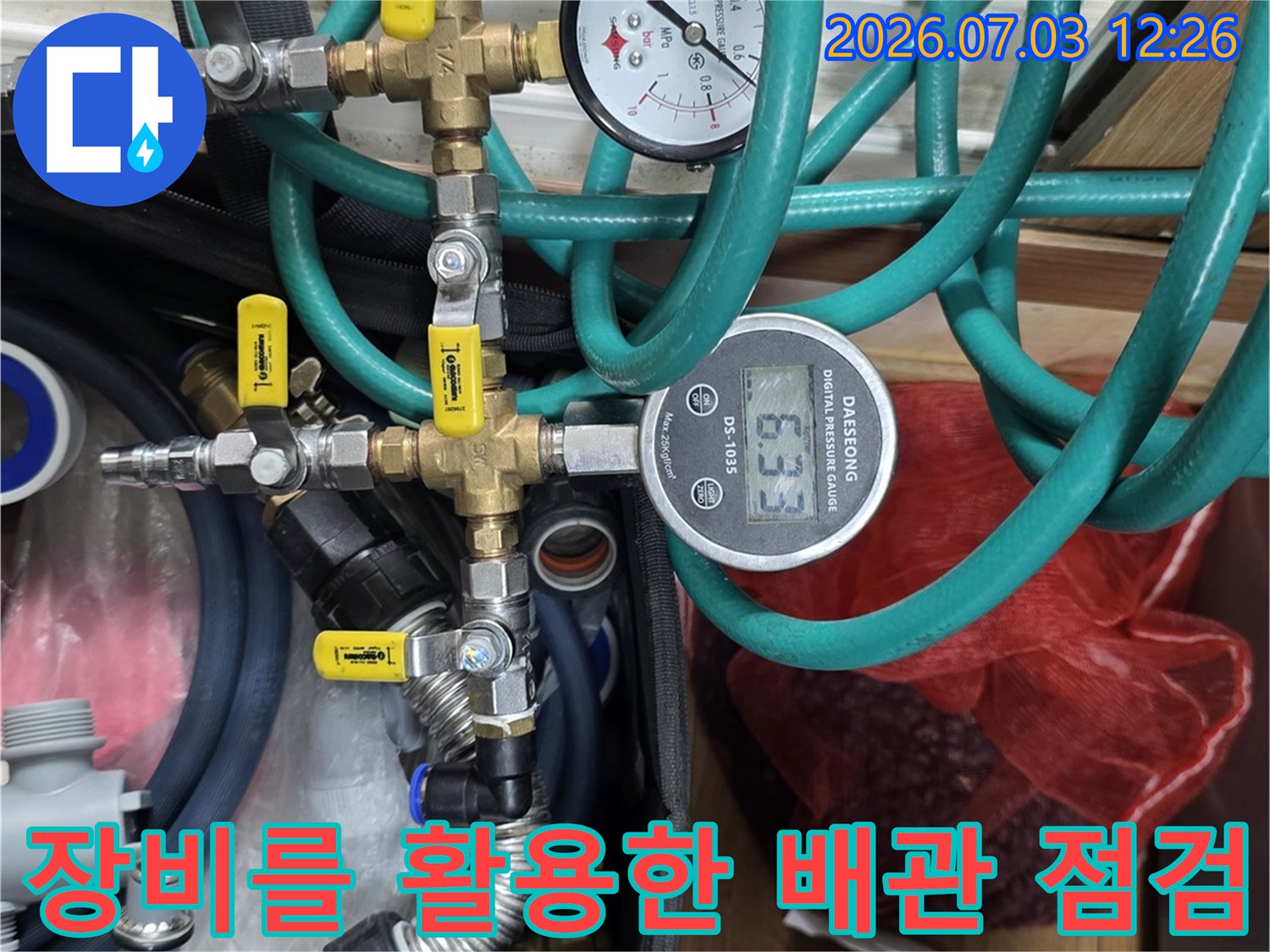 다양한 컬러의 호스가 연결된 공압 테스트 장비로 배관 상태를 정밀하게 검사하는 장면