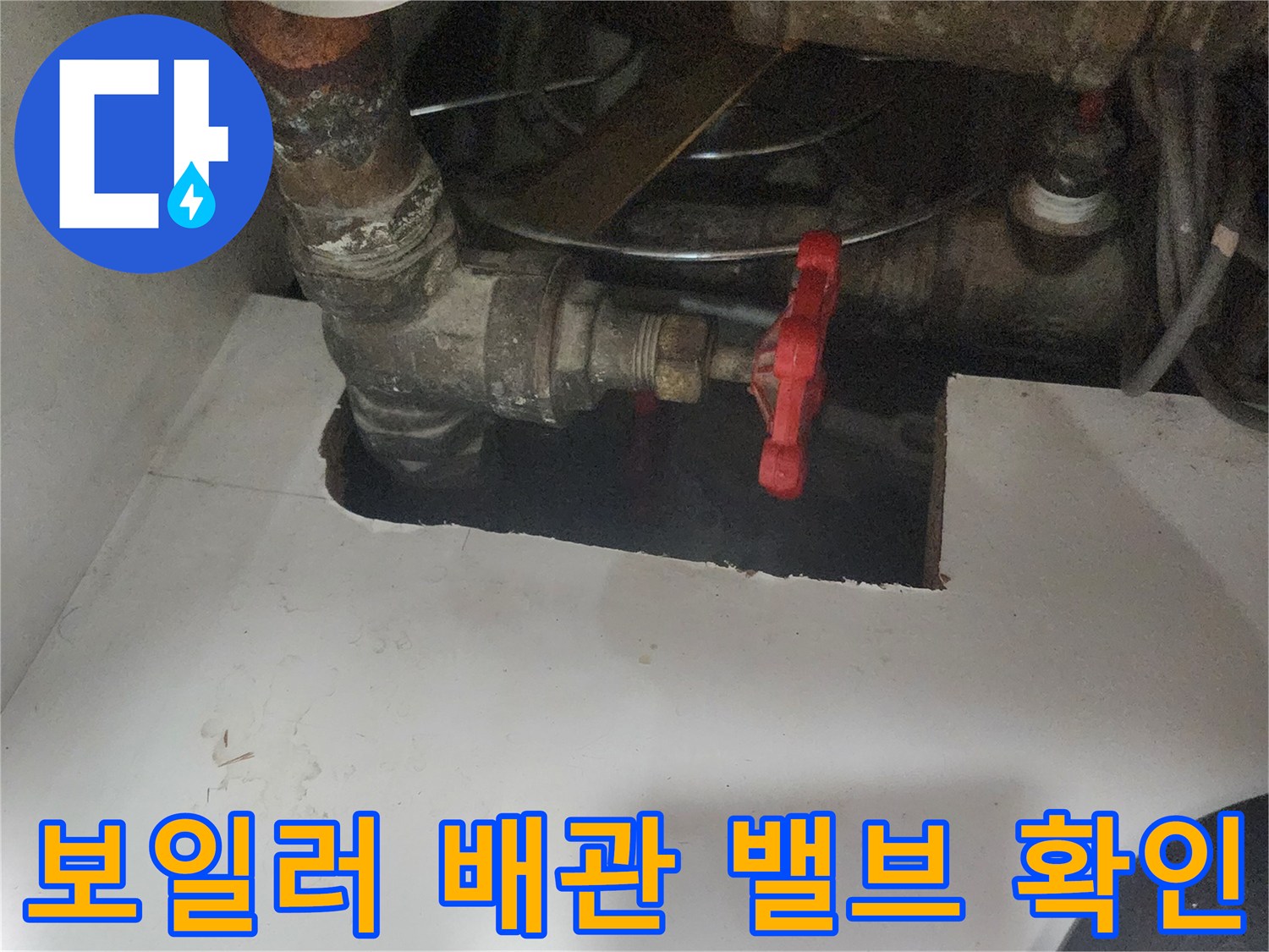 붉은색 핸들 밸브와 연결된 금속 배관 부위