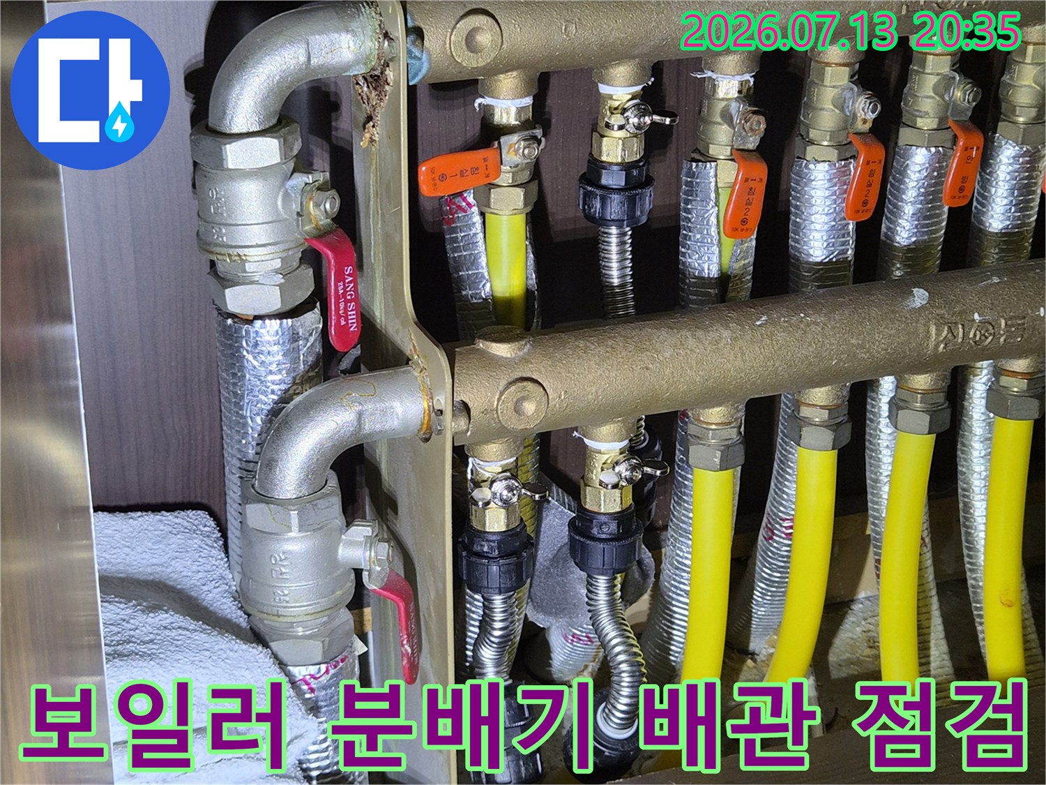 노란색 보호재로 감싸진 보일러 분배기 및 스테인리스 연결부 상세 사진