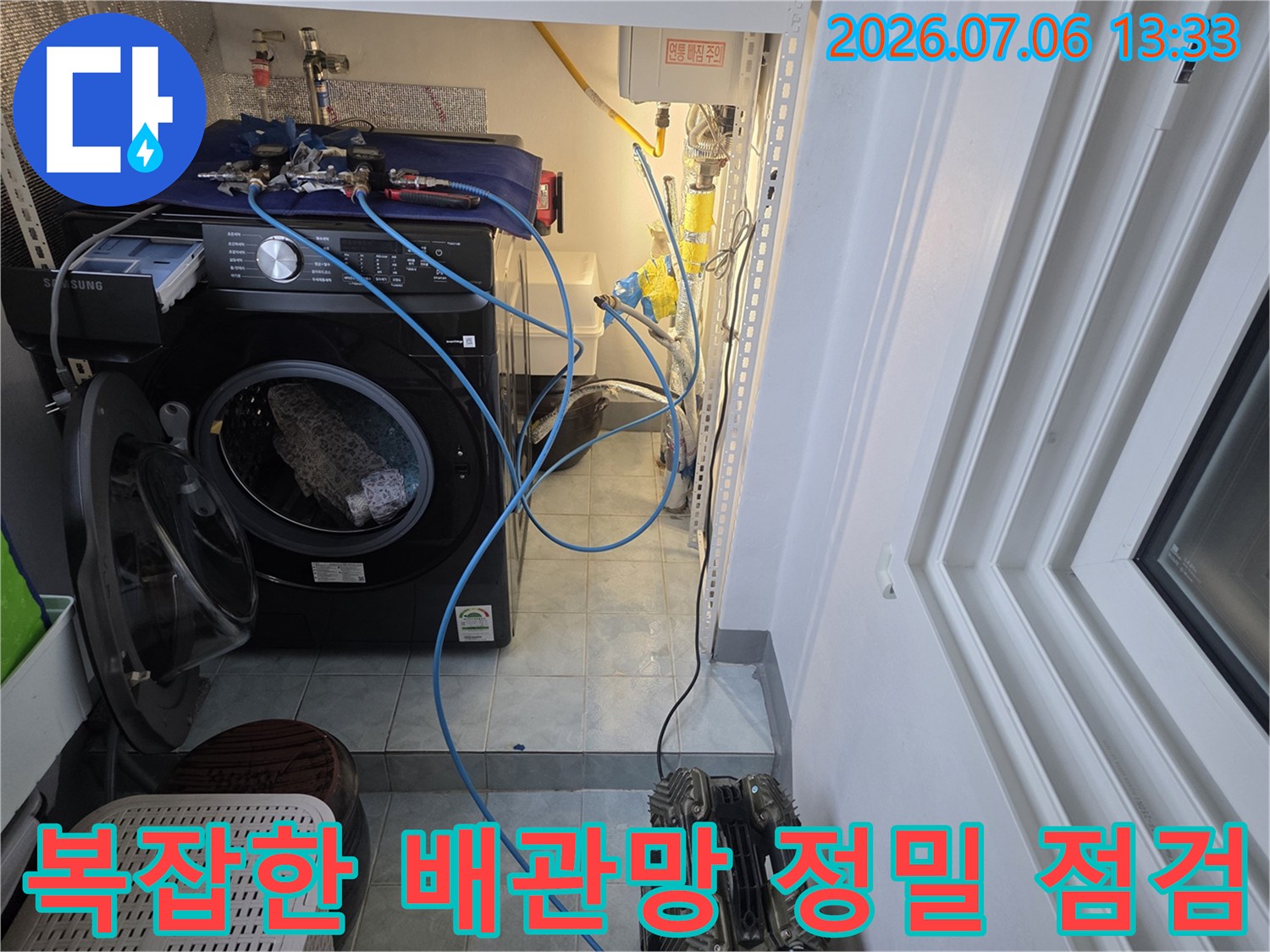 세탁기 뒤편으로 복잡하게 얽힌 수도 배관과 계량부 확인
