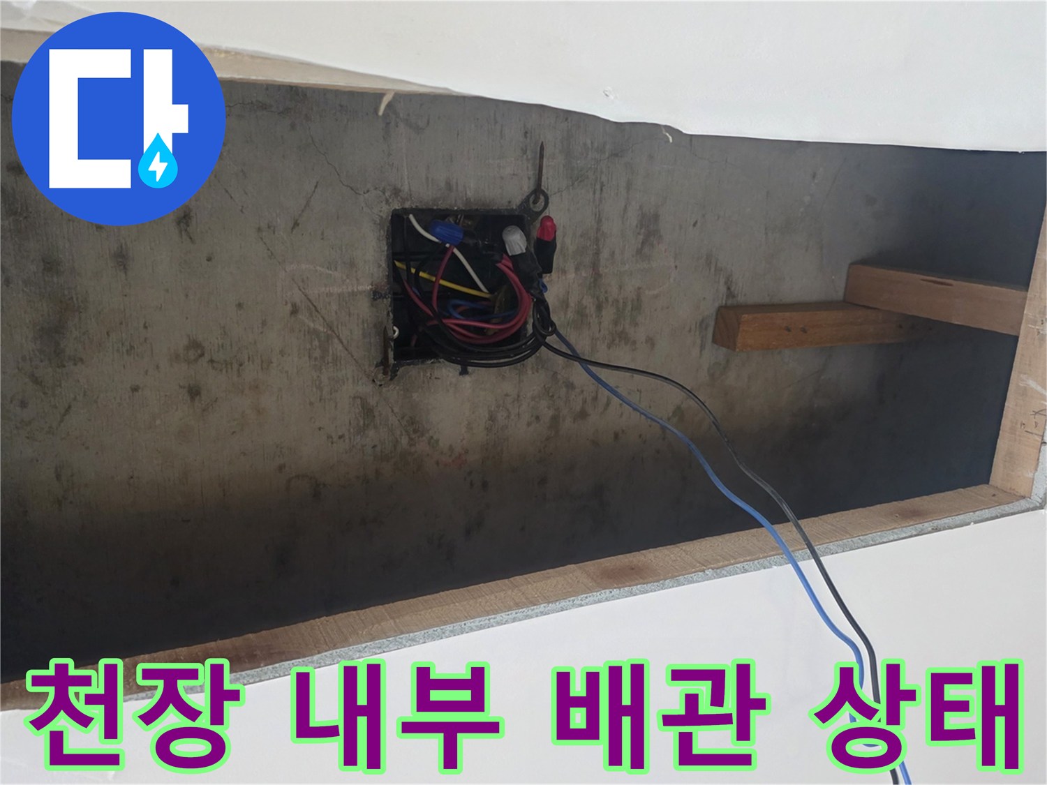 천장 내부의 전기 박스와 목재 지지대 사이로 보이는 배관 주변 공간