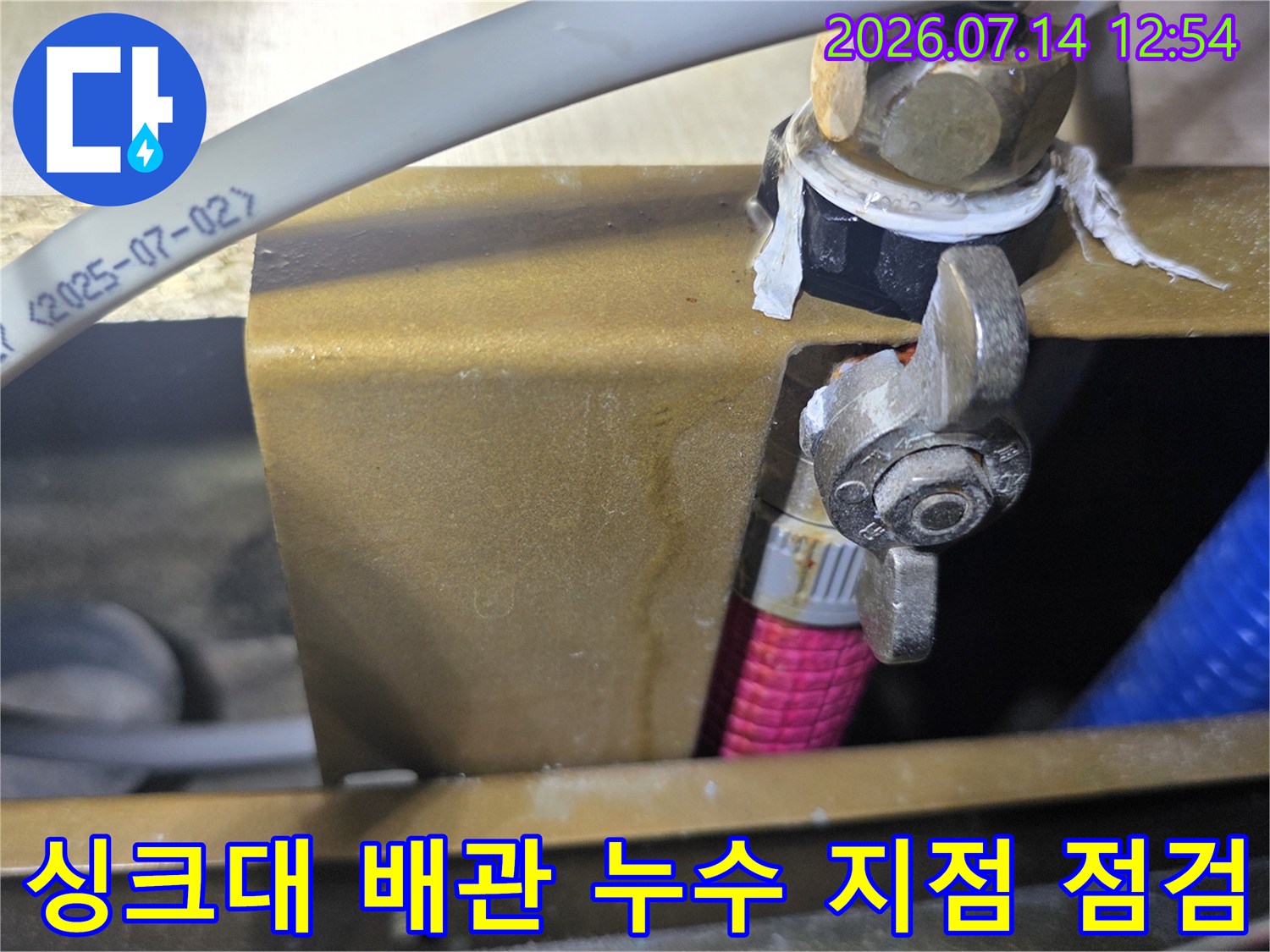 싱크대 하부 공간에서 확인된 노출 배관과 밸브 연결 부위의 상태를 점검하는 모습