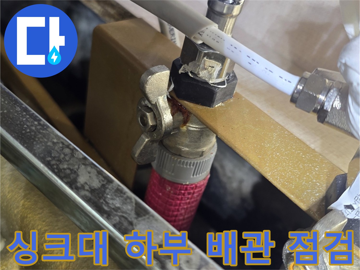 싱크대-하부-배관-연결-부위-정밀-점검-중인-모습