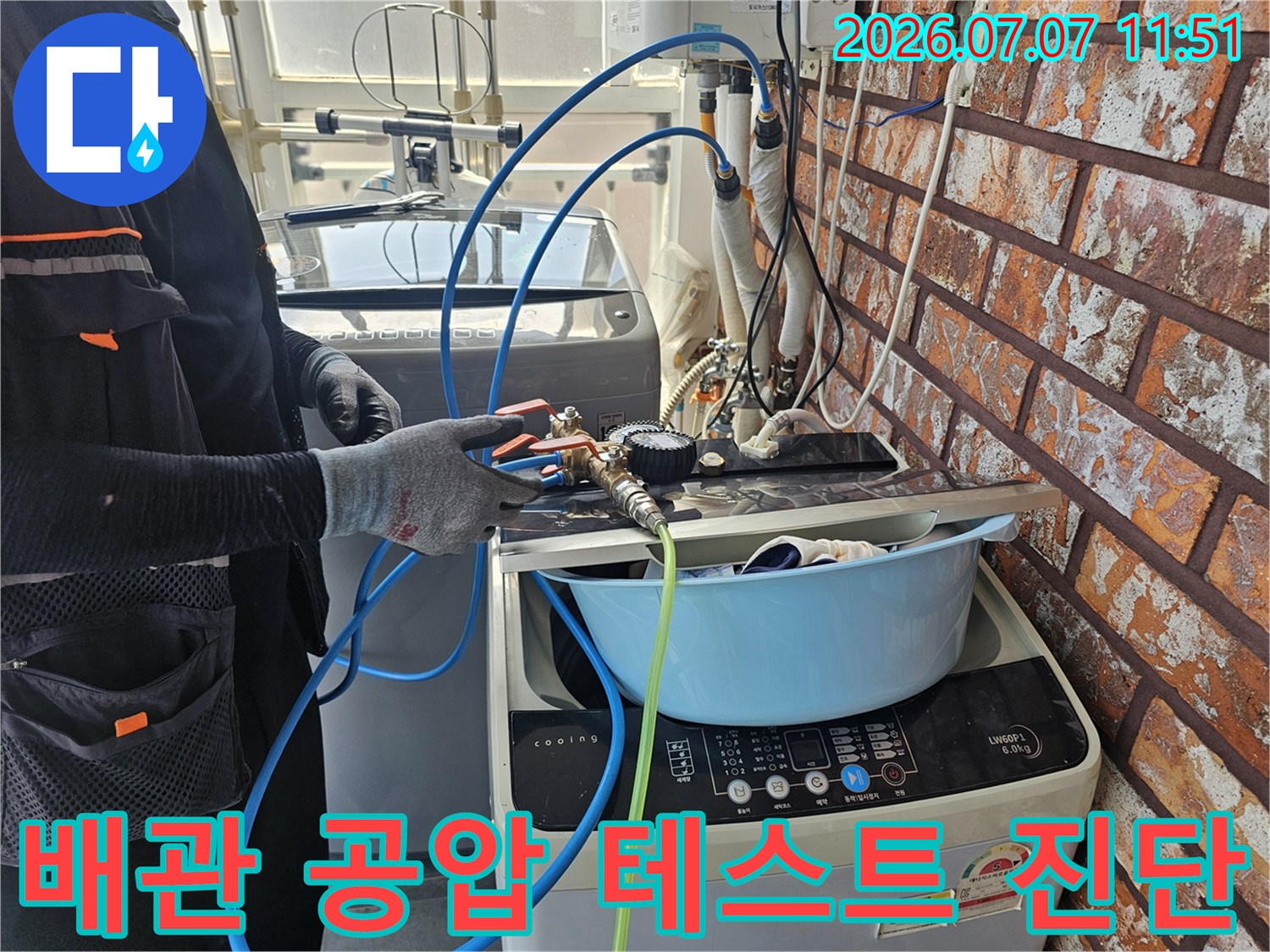 작업자가 장갑을 끼고 배관에 연결된 호스를 점검하는 누수 정밀 진단 현장